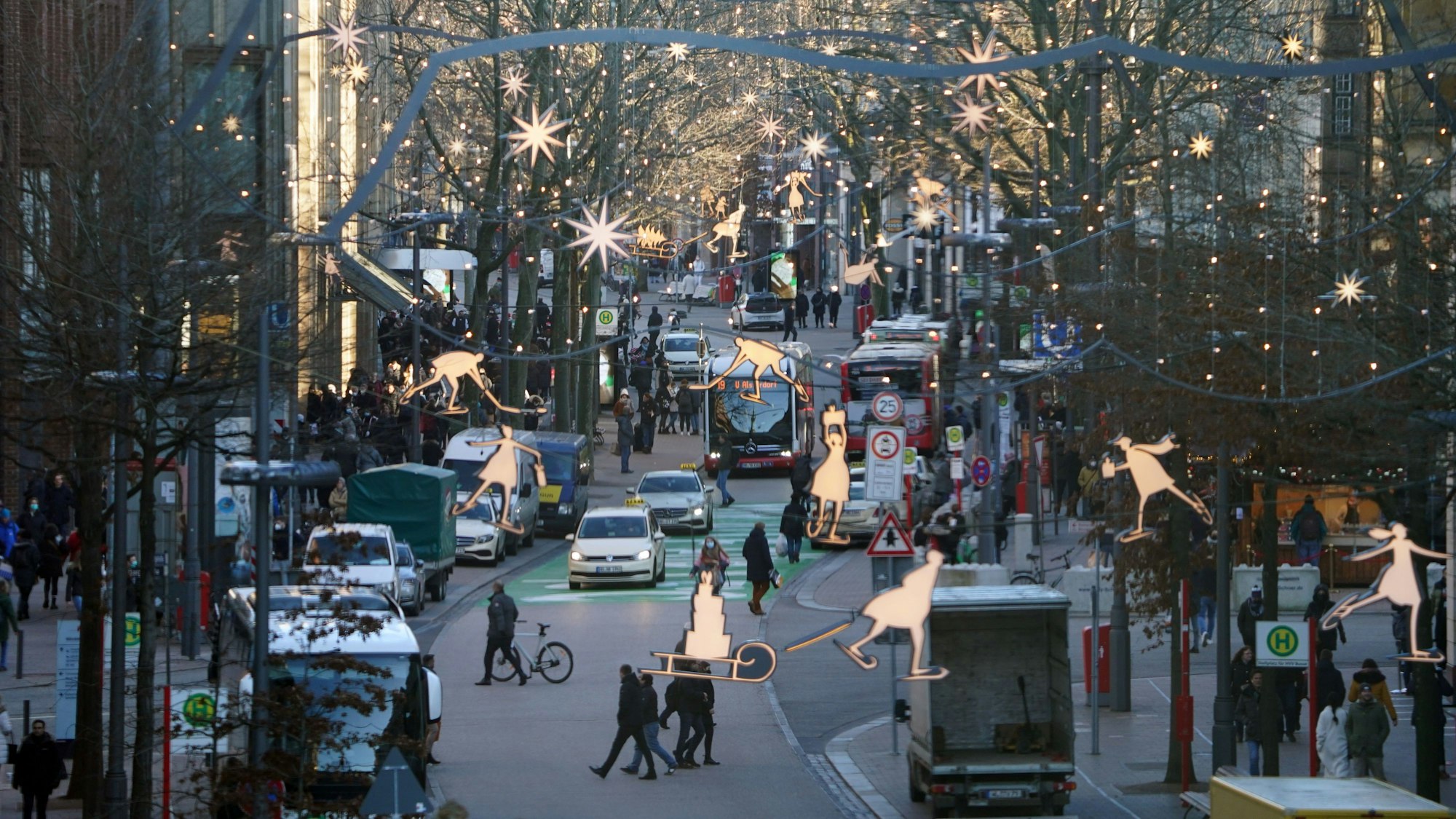 Passanten erledigen Einkäufe am 21. Dezember in der weihnachtlich geschmückten Innenstadt von Hamburg. Das Bundesland verschärft seine Corona-Maßnahmen für Heiligabend.