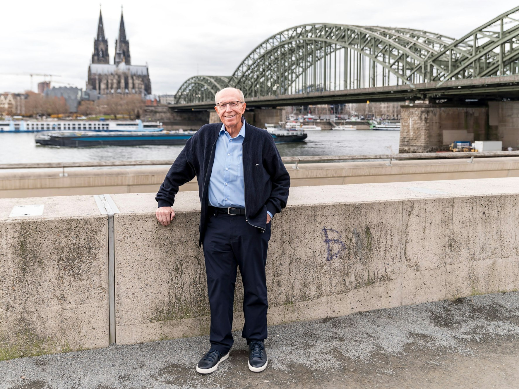 Reiner Calmund steht vor dem Hyatt-Hotel in Köln am Rhein-Ufer.