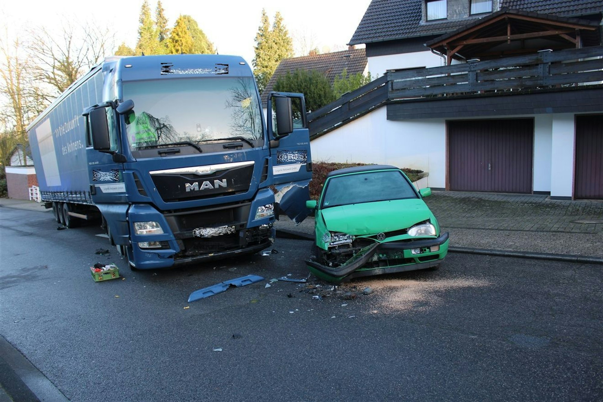 Der verunglückte Lkw steht neben einem demolierten Auto.