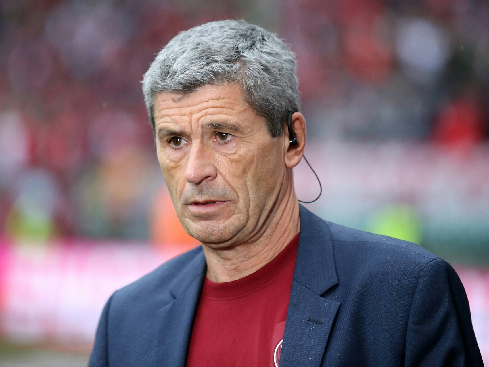 Markus Merk trägt einen Anzug und darunter ein rotes Kaiserslautern-Shirt.