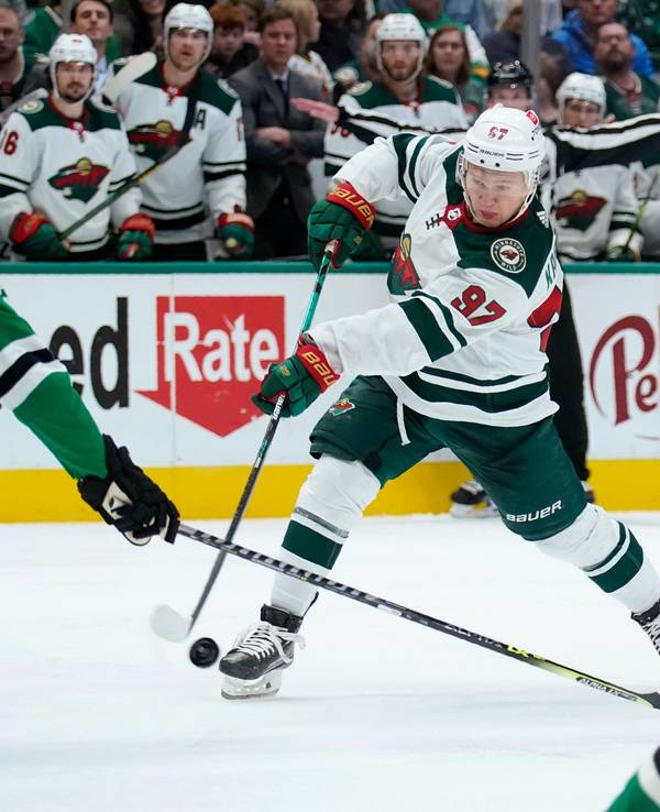 Dallas Stars defenseman Ryan Suter (20) defends against a shot by Minnesota Wild left wing Kirill Kaprizov (97) in the second period of an NHL hockey game in Dallas, Monday, Dec. 20, 2021. (AP Photo/Tony Gutierrez)