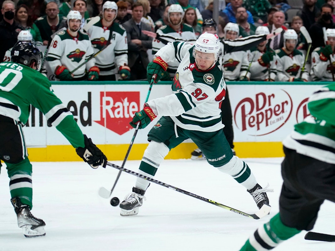 Dallas Stars defenseman Ryan Suter (20) defends against a shot by Minnesota Wild left wing Kirill Kaprizov (97) in the second period of an NHL hockey game in Dallas, Monday, Dec. 20, 2021. (AP Photo/Tony Gutierrez)