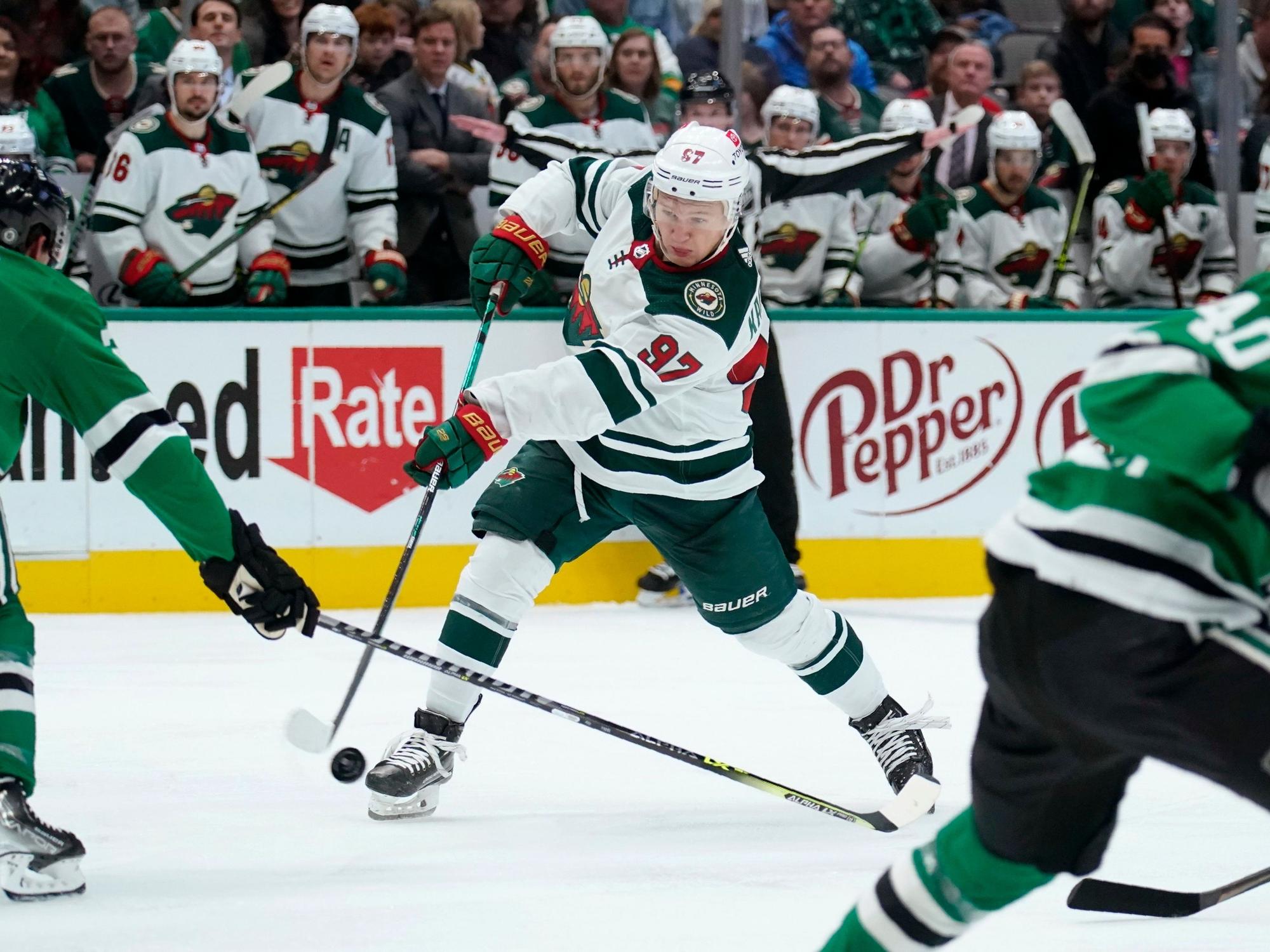 Dallas Stars defenseman Ryan Suter (20) defends against a shot by Minnesota Wild left wing Kirill Kaprizov (97) in the second period of an NHL hockey game in Dallas, Monday, Dec. 20, 2021. (AP Photo/Tony Gutierrez)