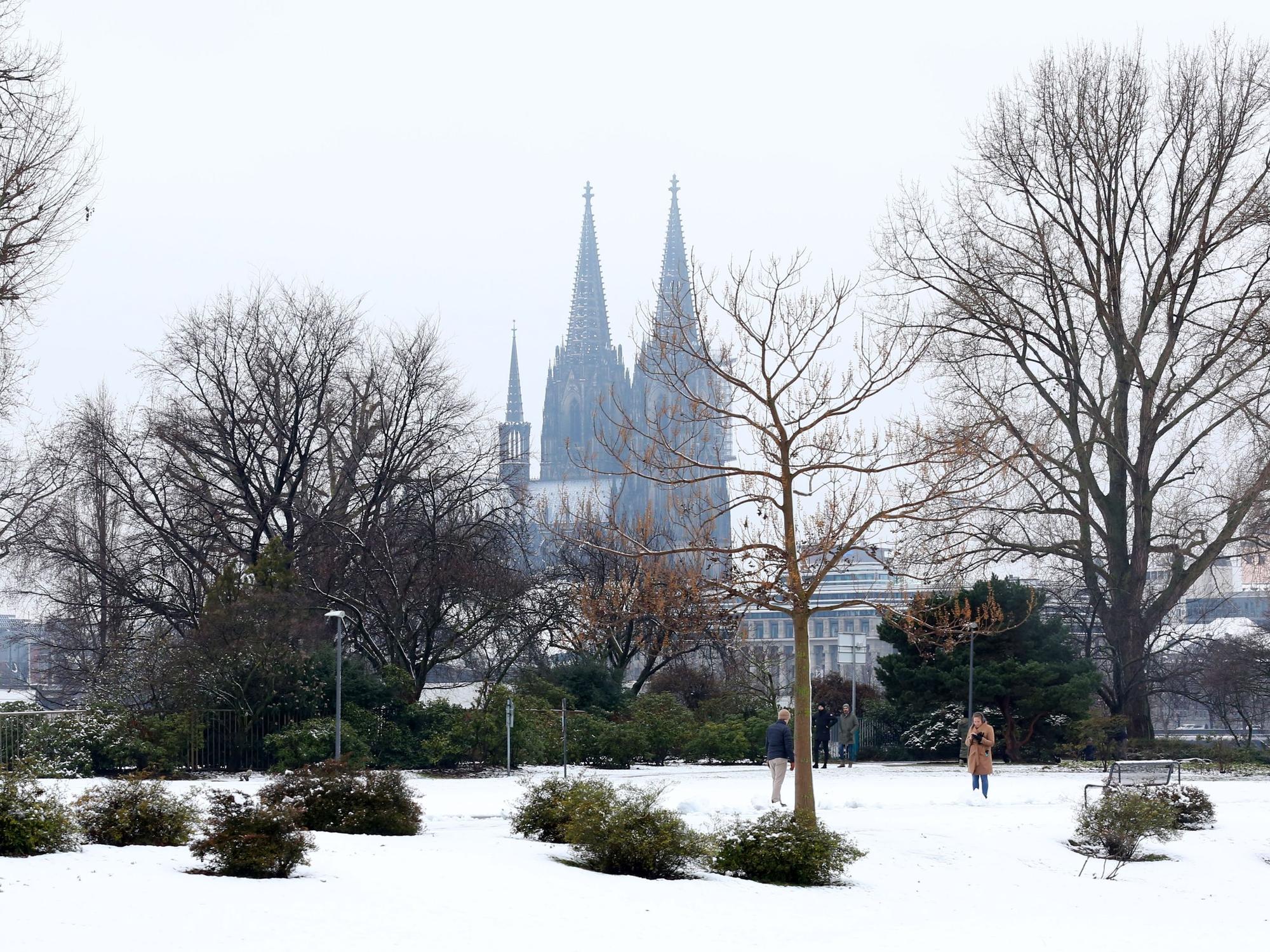 Ein verschneiter Park, im Hintergrund zwei Kirchtürme