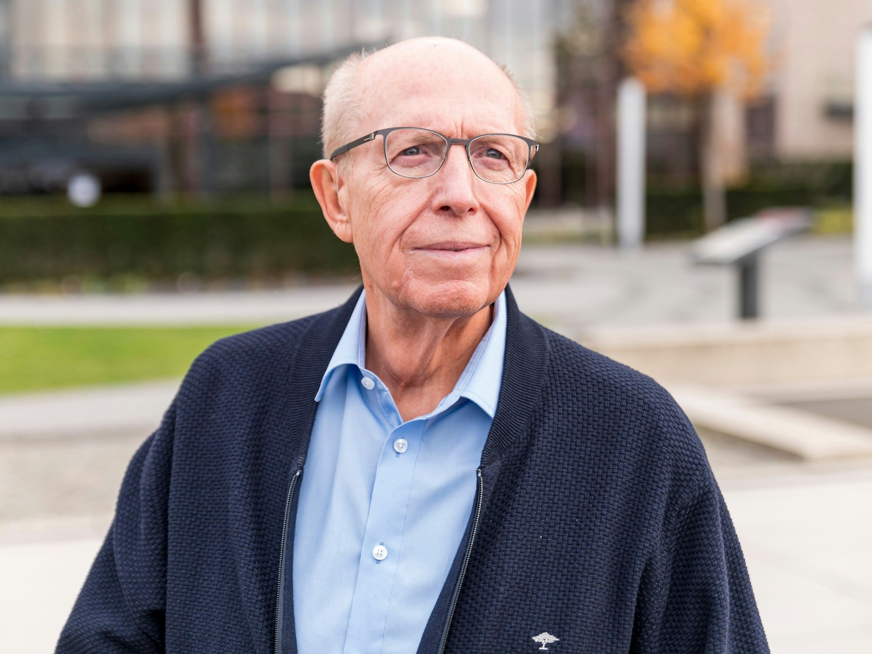 Reiner Calmund schaut vor dem Hyatt-Hotel Richtung Rhein.