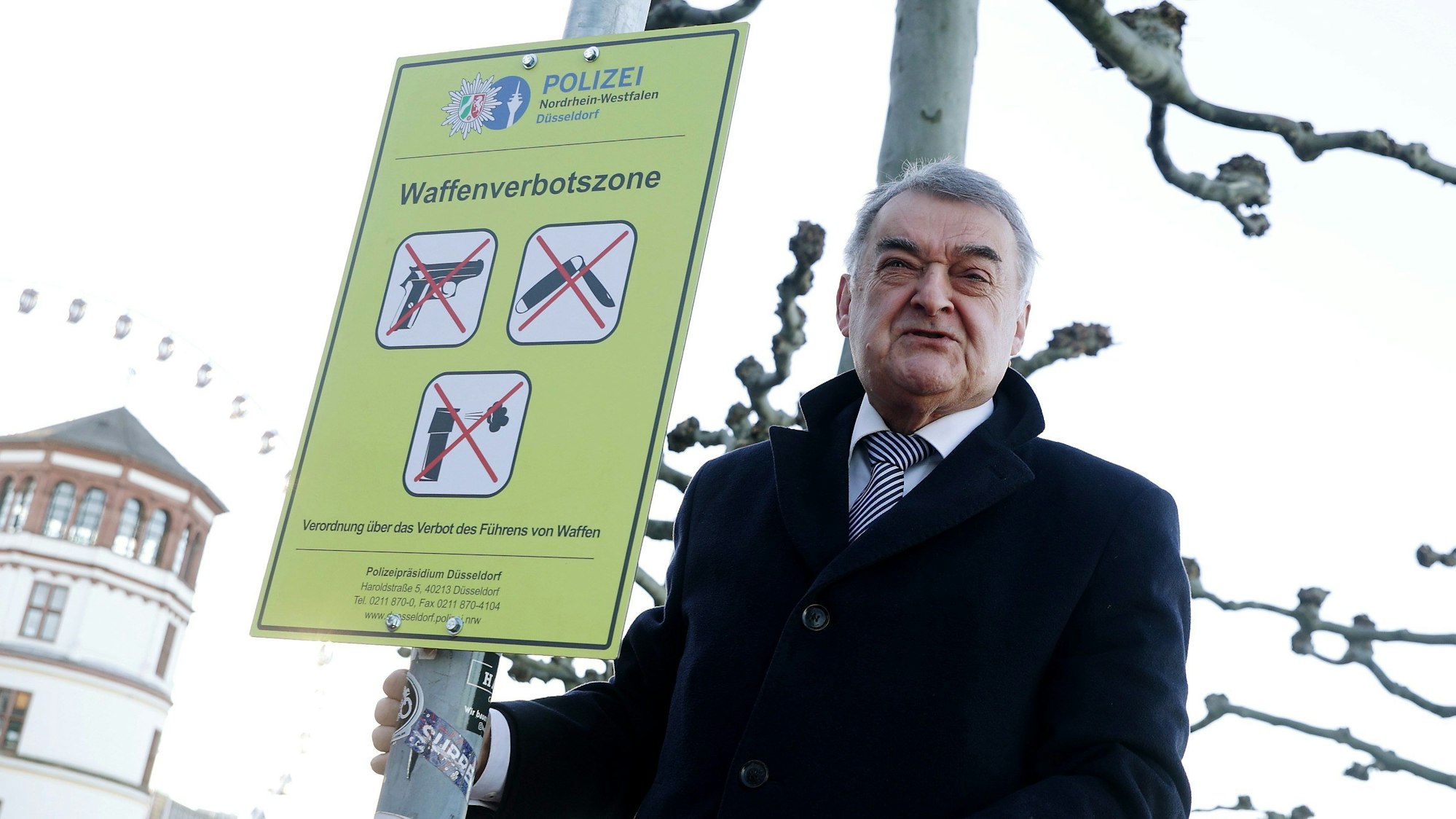 Düsseldorf: NRW-Innenminister Herbert Reul (CDU) befestigt auf der Düsseldorfer Rheinufer Promenade ein Schild zur Waffenverbotszone.