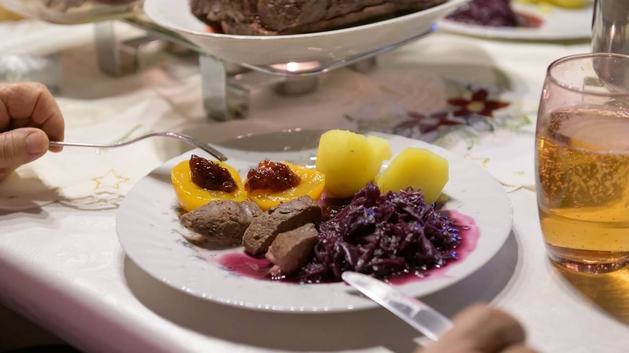 Hamburg: Damhirsch-Rücken mit Kartoffeln und Rotkohl sowie Preiselbeergelee auf Aprikosen liegen verzehrfertig auf einem Teller an Heiligabend.