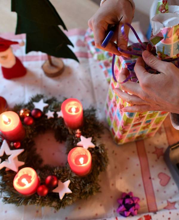 Eine Frau packt in unserem Symbolbild am vierten Advent Weihnachtsgeschenke ein. Wir erklären, welche Corona-Regeln an Weihnachten in NRW gelten.