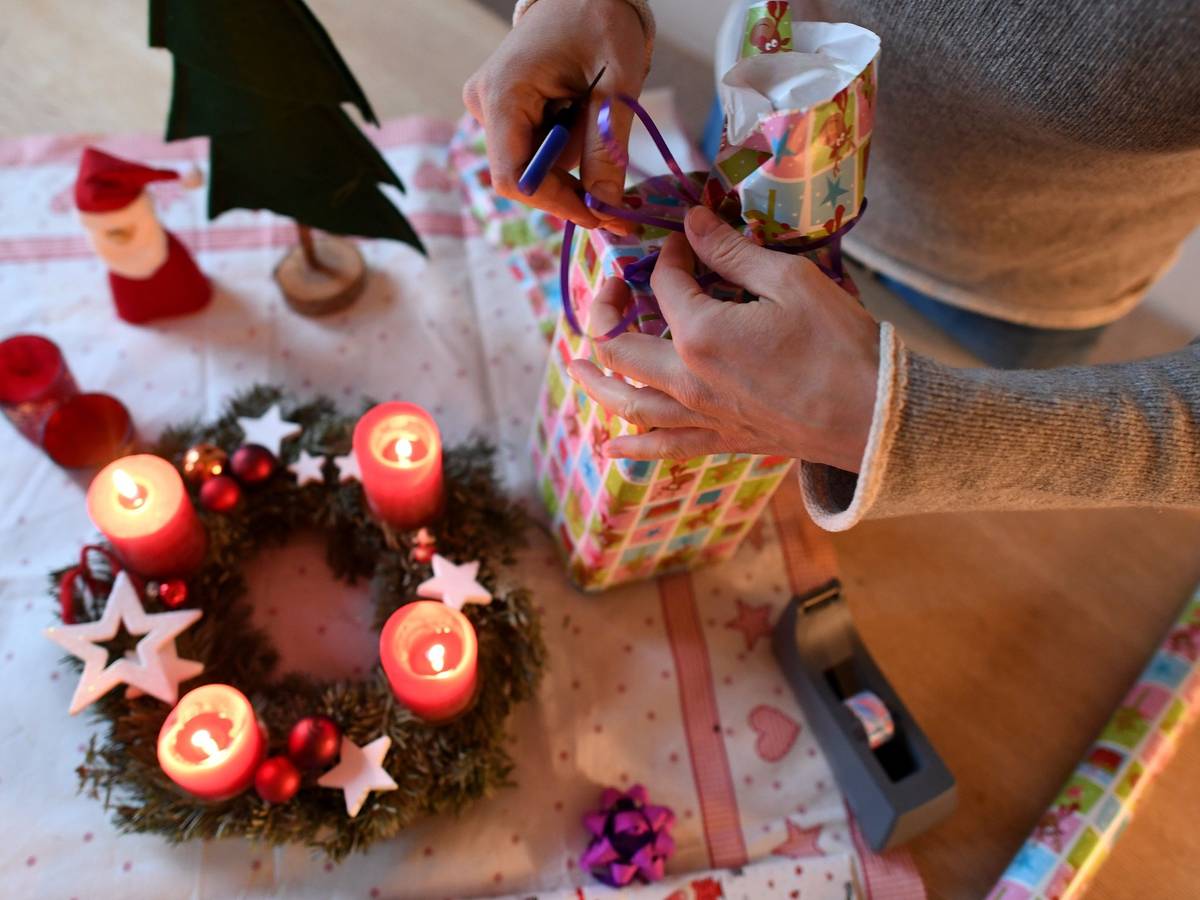 Eine Frau packt in unserem Symbolbild am vierten Advent Weihnachtsgeschenke ein. Wir erklären, welche Corona-Regeln an Weihnachten in NRW gelten.