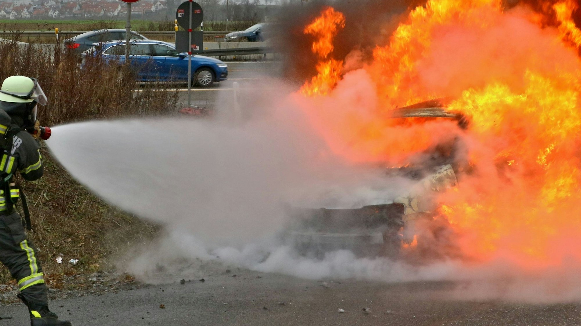 Einsatzkräfte der Feuerwehr löschen ein Fahrzeug (Symbolfoto).