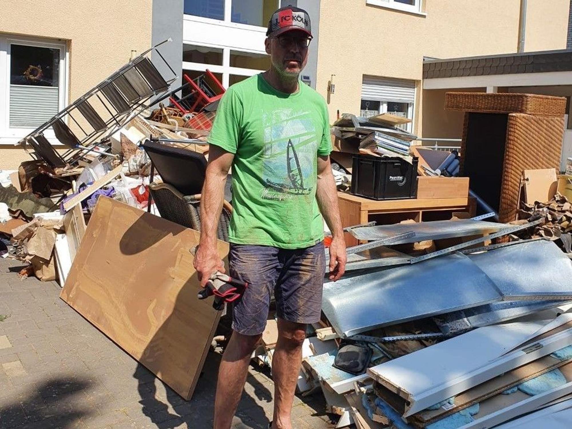 Markus Jonas ist ein Flut-geschädigter Kölner, hier steht er vor dem Müllberg seines Hauses in Weilerswist.