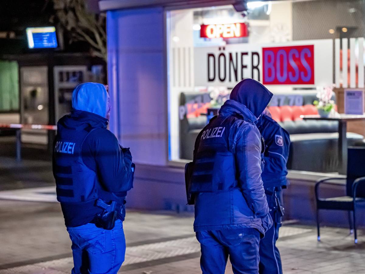 Polizisten stehen vor einem Imbiss