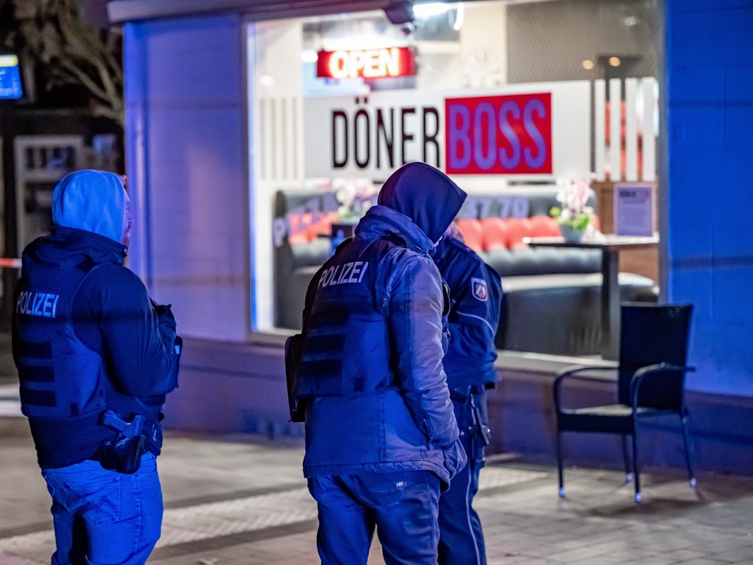 Polizisten stehen vor einem Imbiss