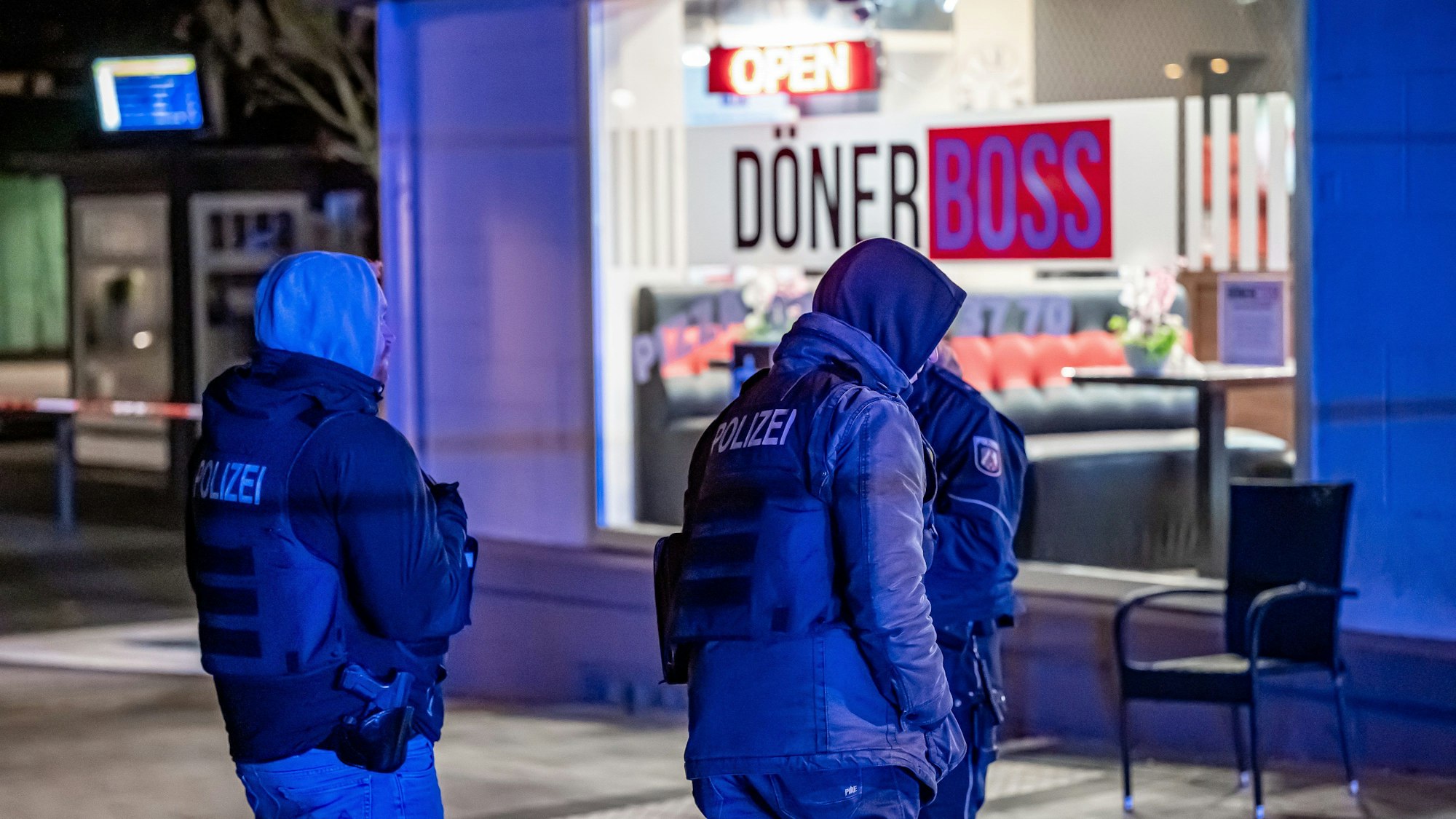 Polizisten stehen vor einem Imbiss