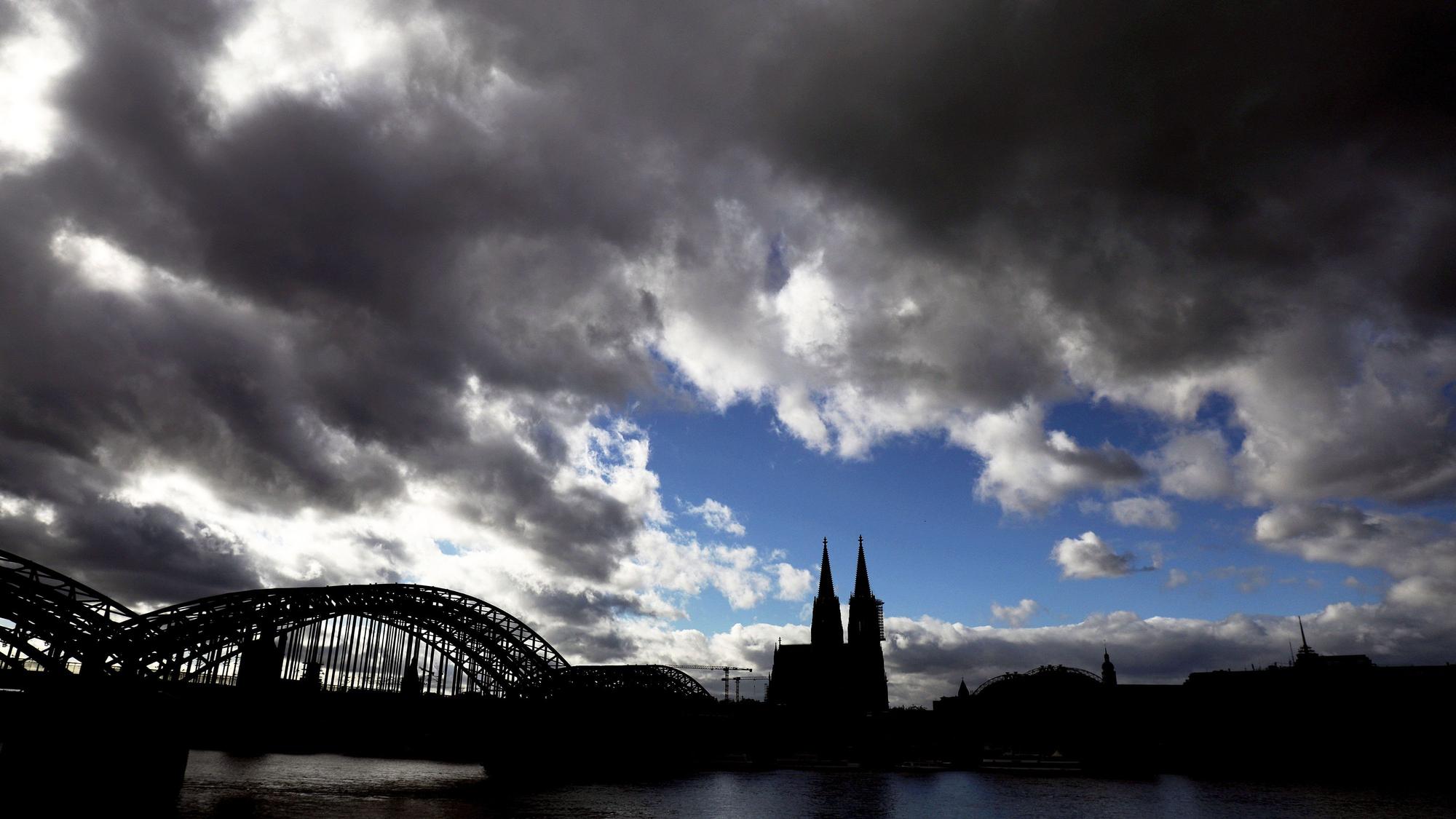 Dunkle Wolken ziehen über dem Dom hinweg. Nach den vorliegenden Zahlen gelten mittlerweile fast alle Regionen in NRW als Corona-Risikogebiete.