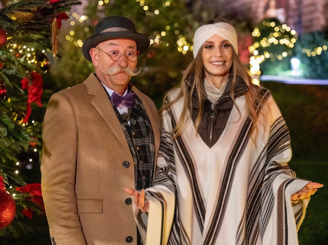 Horst Lichter und Cathy Hummels stehen bei der Weihnachtsaugabe „Bares für Rares XXL“ vor einem Weihnachtsbaum.
