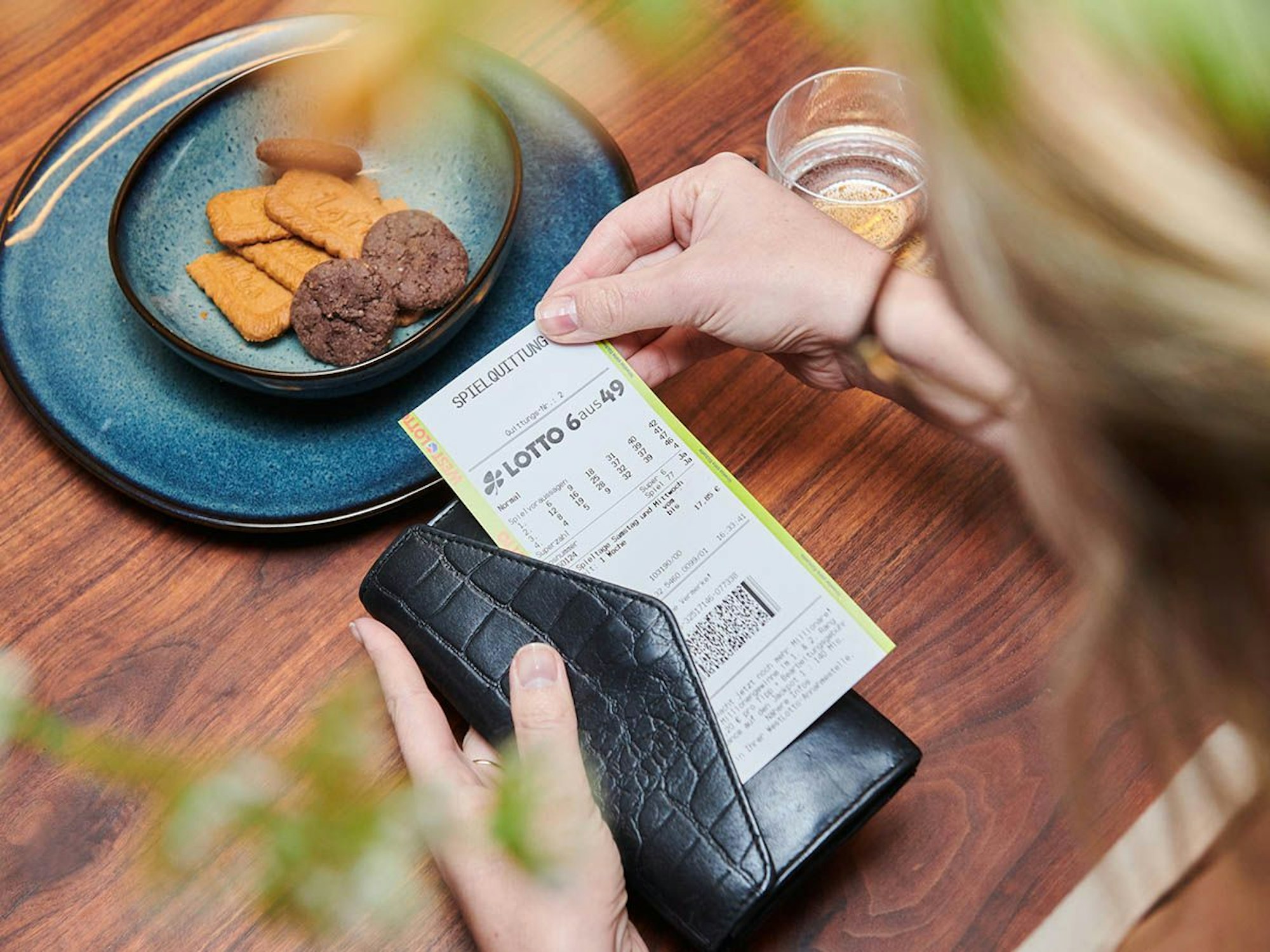Frau hält Spielschein für LOTTO 6aus49 bei WestLotto in der Hand.