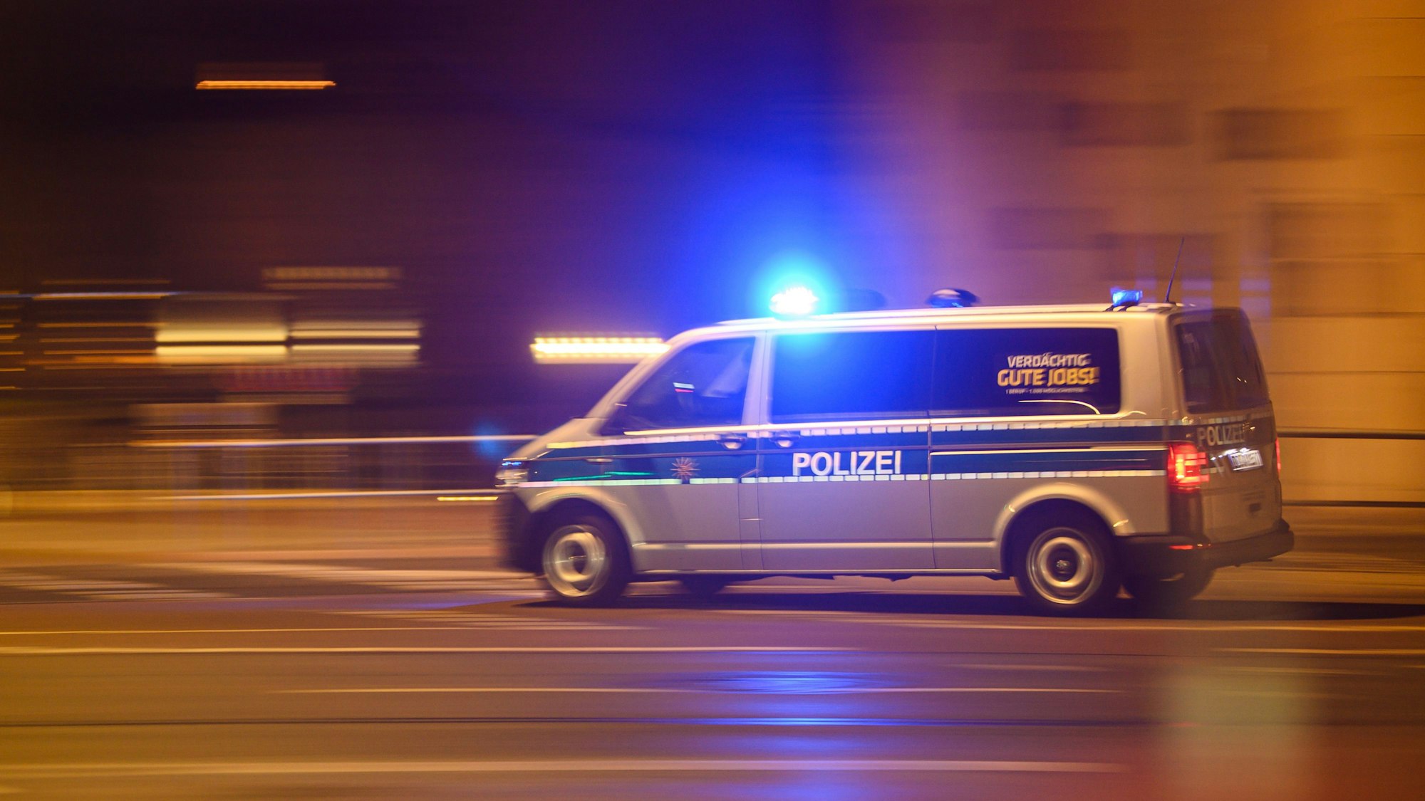 Ein Polizeiwagen mit Blaulicht fährt am Silvesterabend durch die Innenstadt zu einem Einsatz. (Aufnahme mit langer Belichtungszeit). +++ dpa-Bildfunk +++