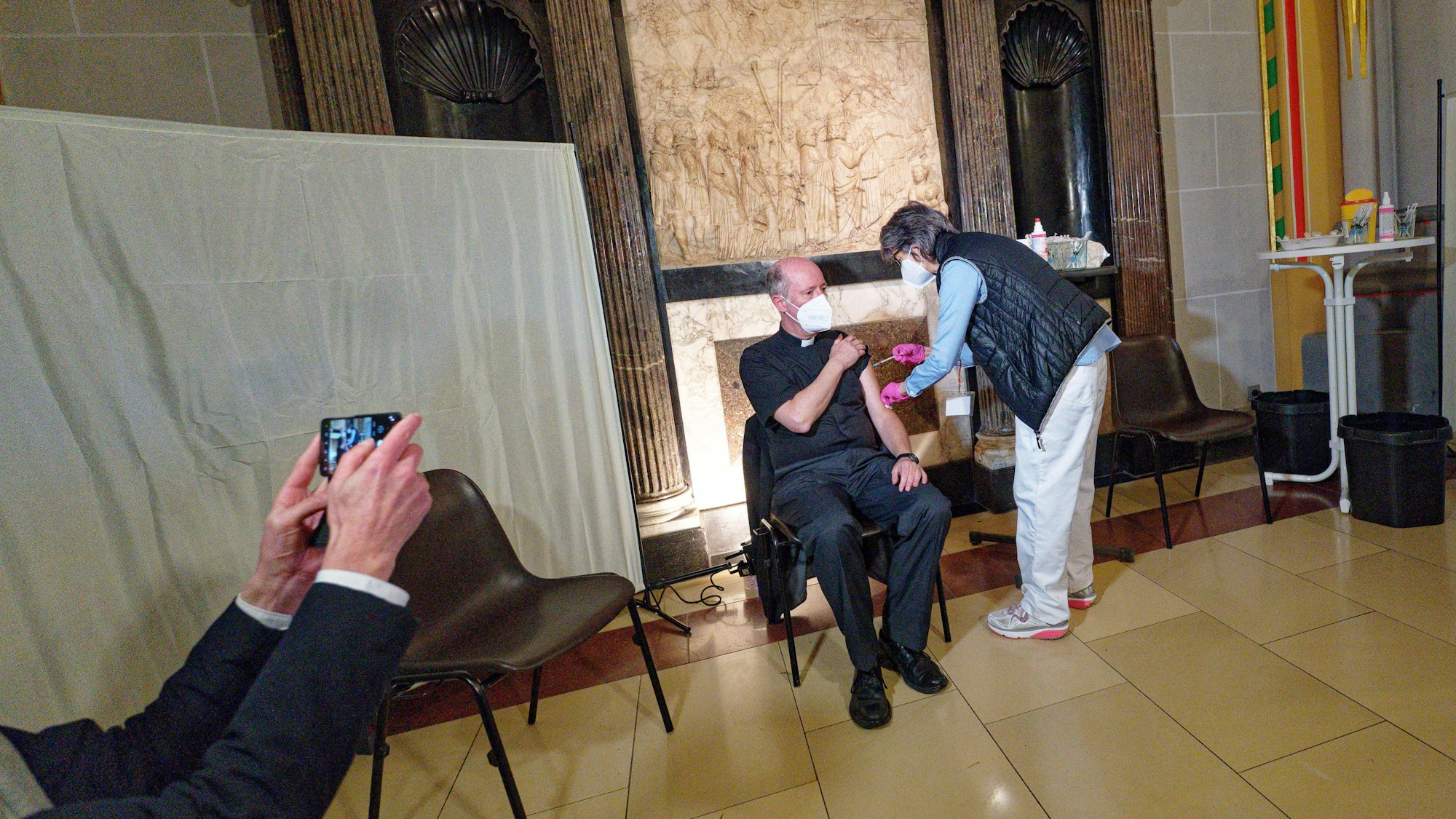 Dompropst Guido Assmann erhält bei einer Impfaktion zu Weihnachten im Dreikönigensaal des Kölner Doms eine Booster-Impfung.