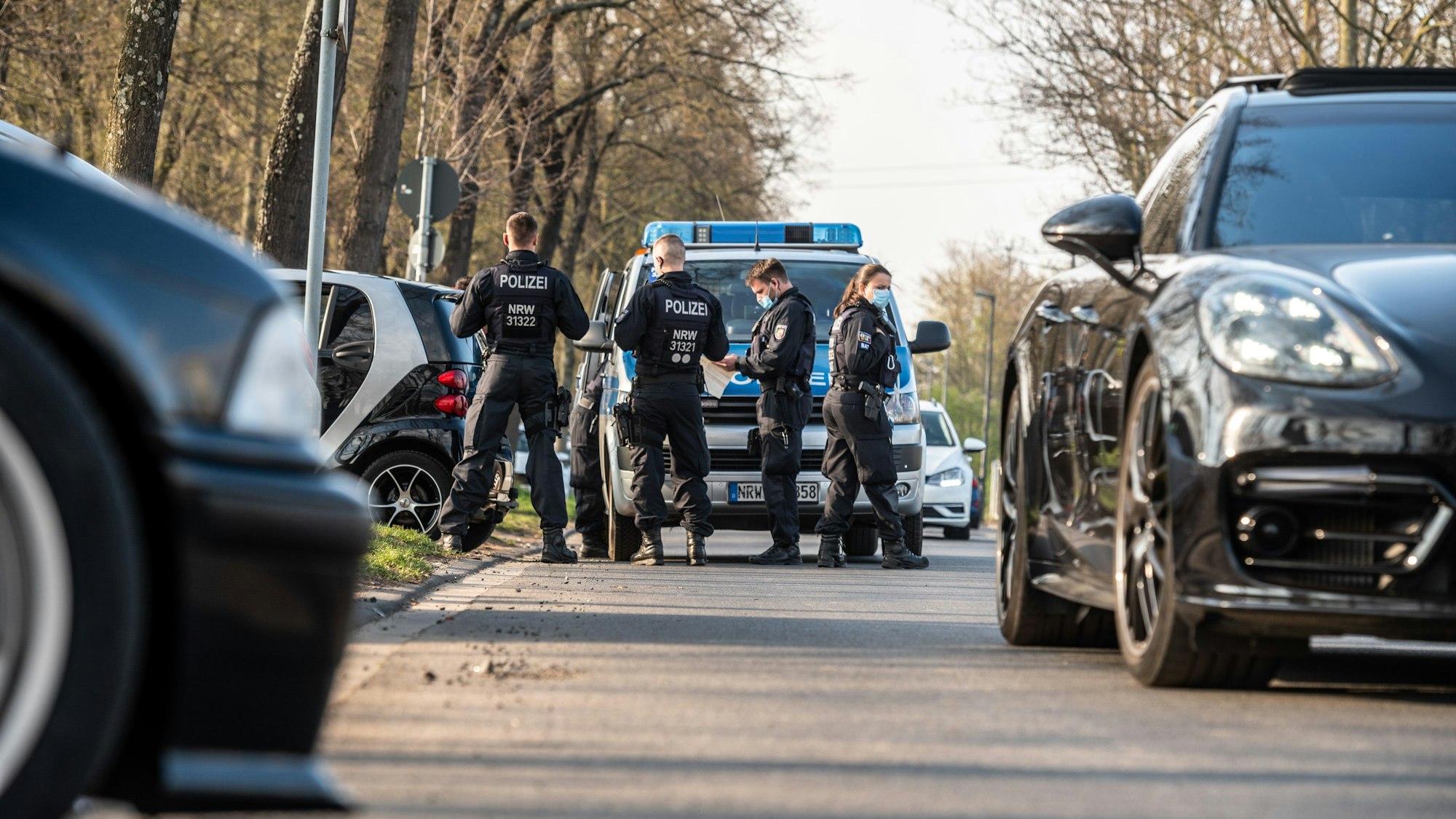 Polizeibeamtinnen und -beamte kontrollieren Autofahrer auf der Alfred-Schütte-Allee.