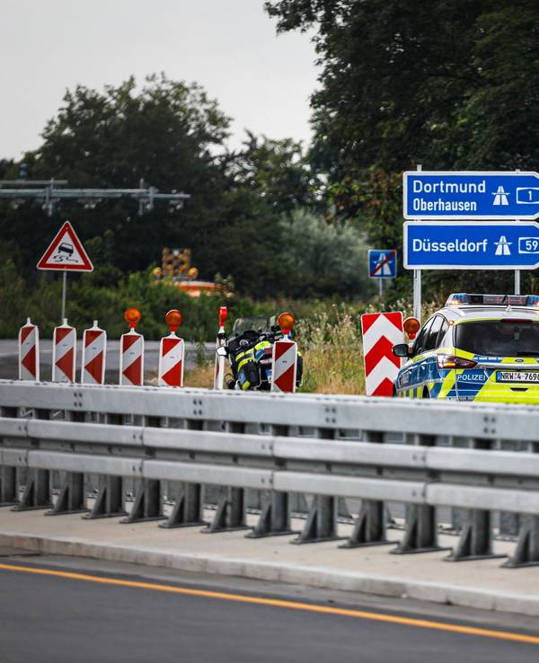 Ein Polizeiauto steht auf einer Autobahn.