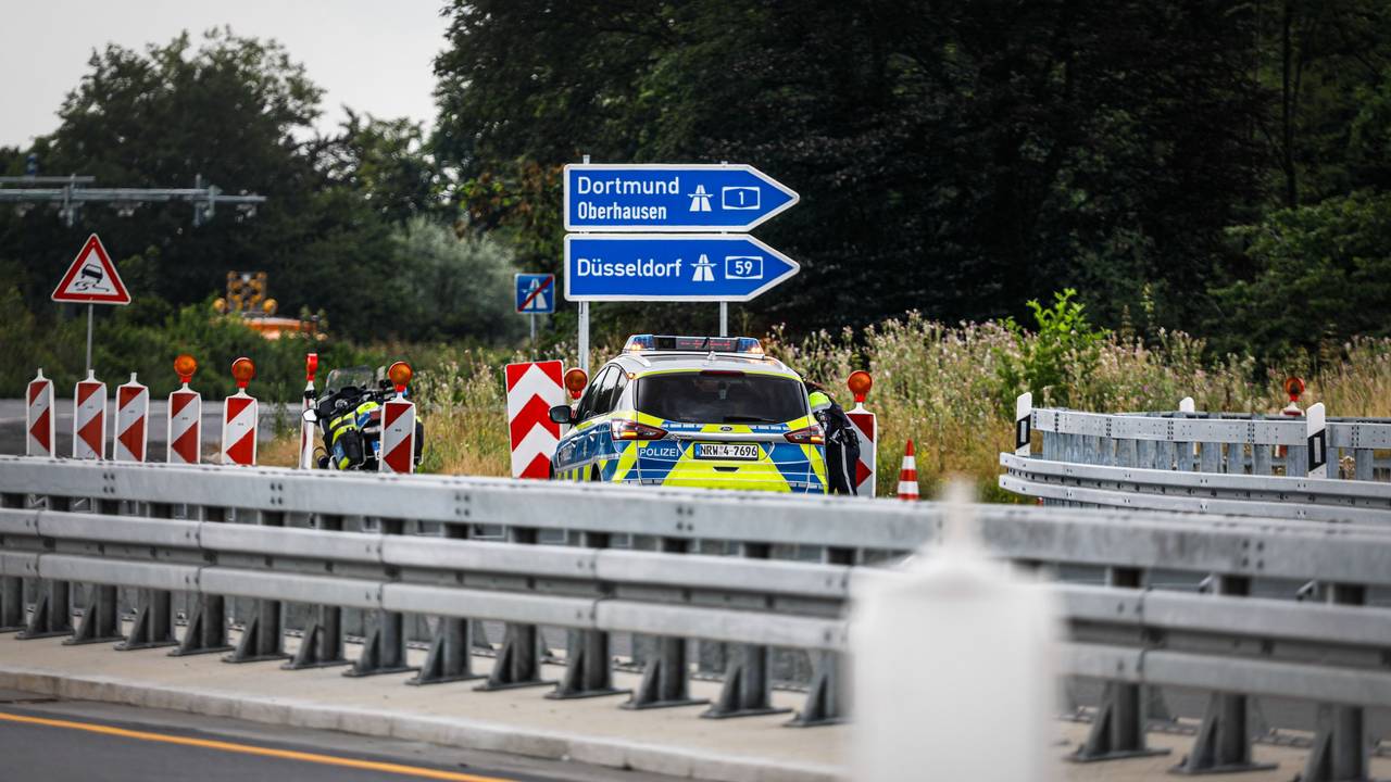 Ein Polizeiauto steht auf einer Autobahn.