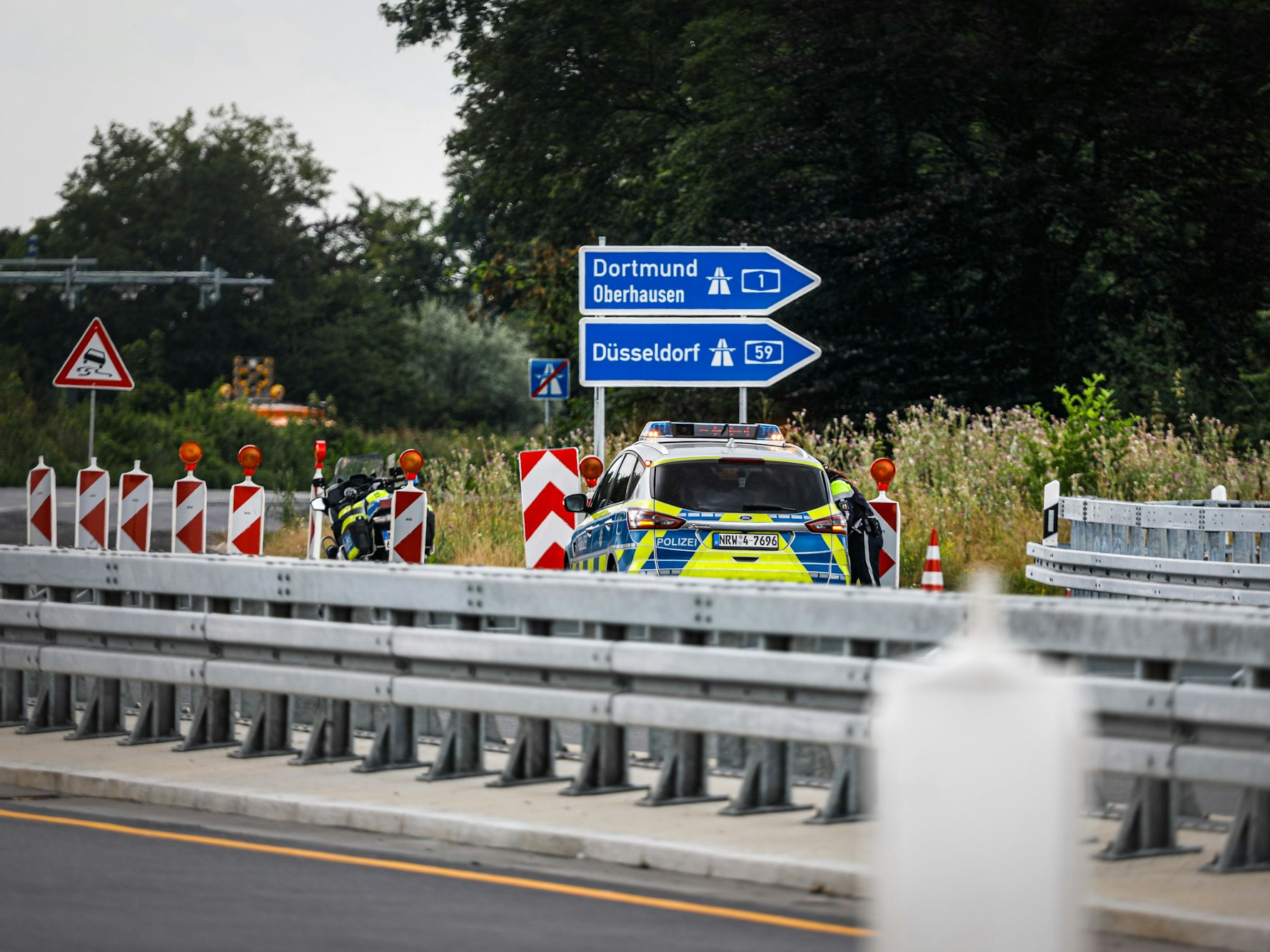 Ein Polizeiauto steht auf einer Autobahn.