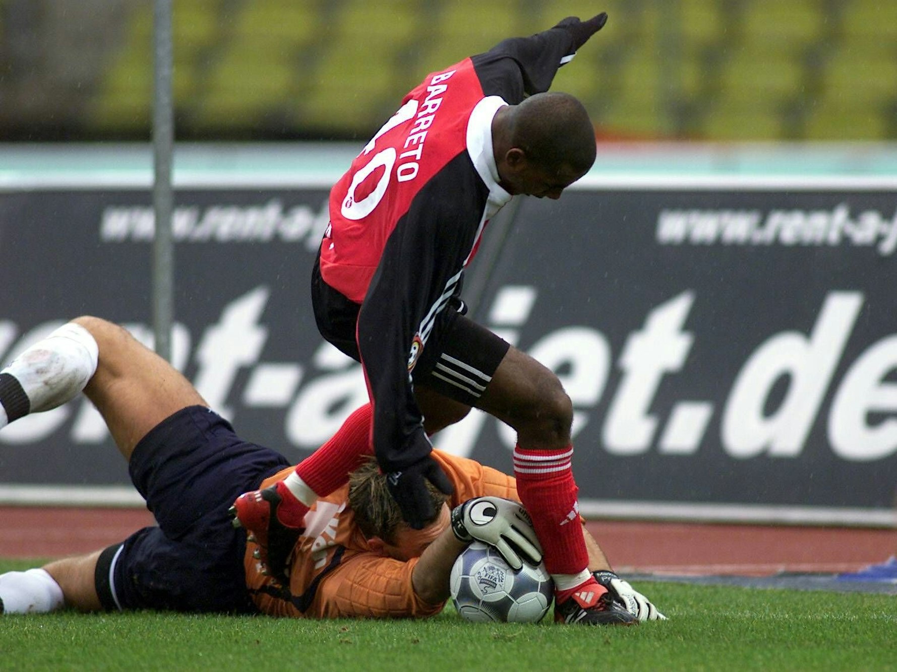 Markus Pröll liegt zwischen den Beinen von Nürnbergs Cacau und hat die Hand auf dem Ball.