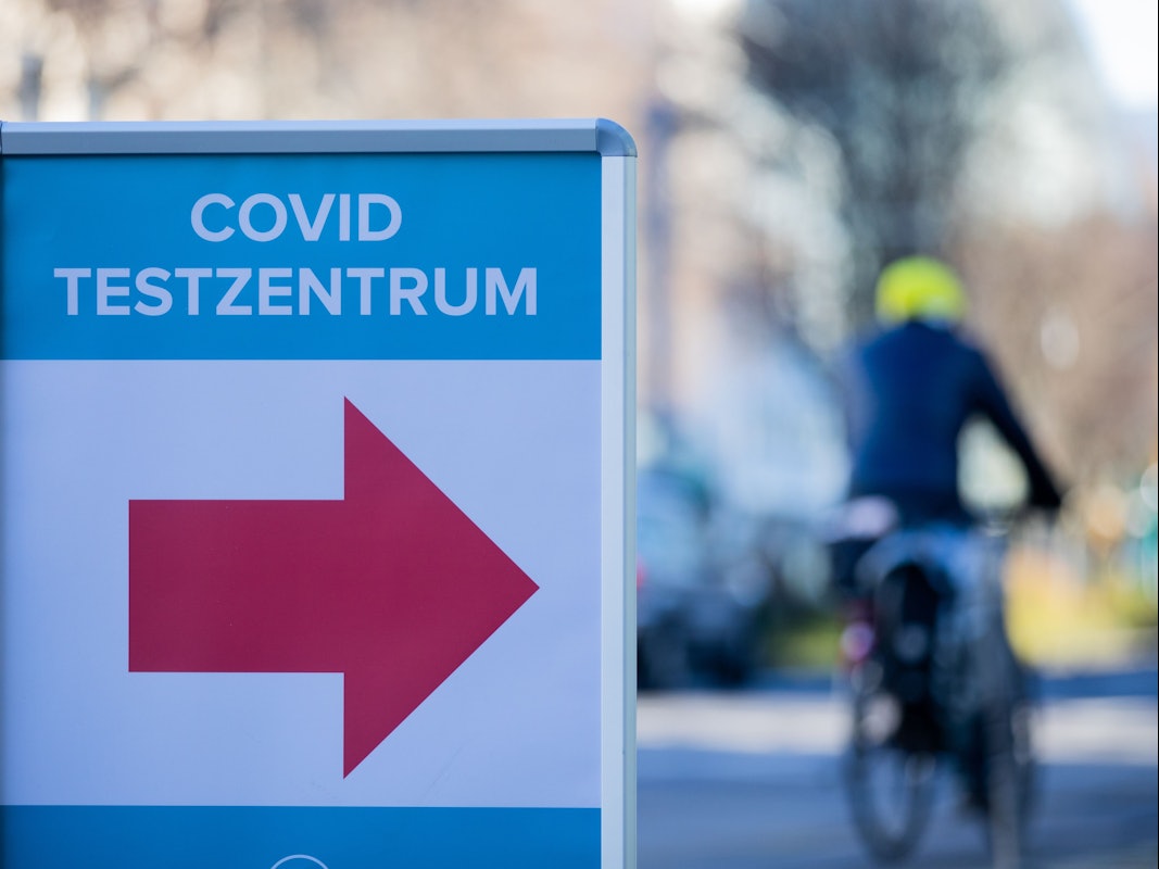 Ein Schild weist im Kölner Stadtzentrum den Weg zu einem Corona-Testzentrum.