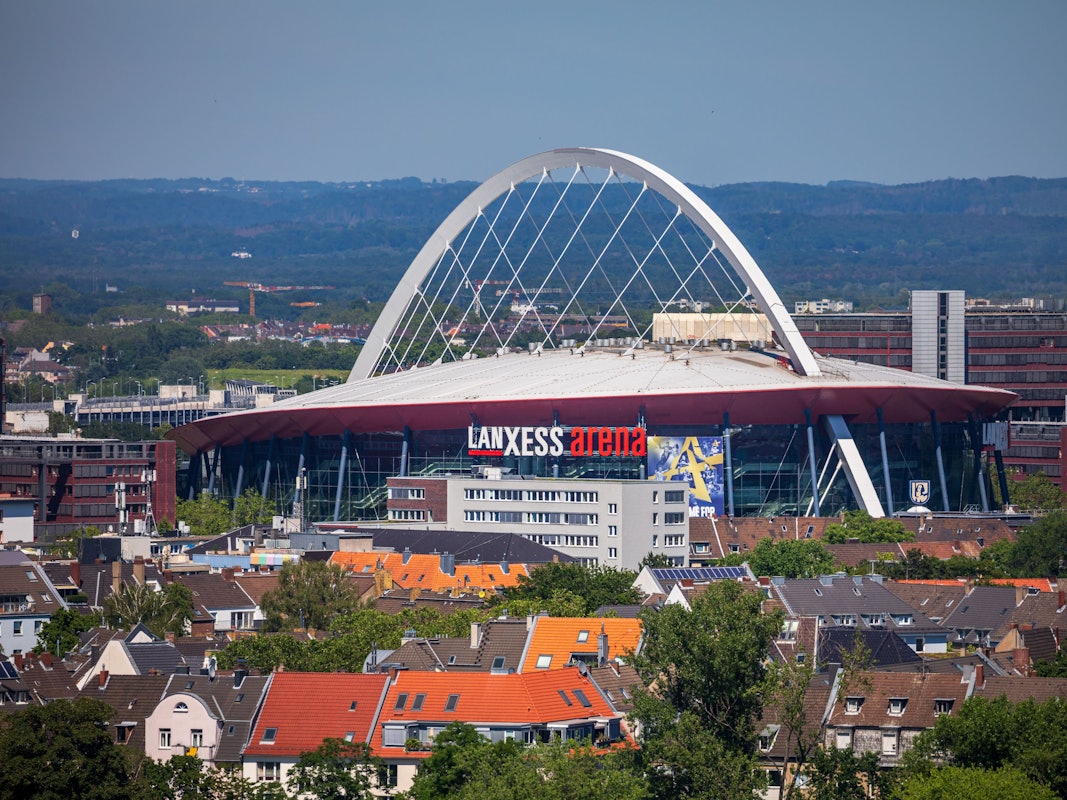 Die Lanxess-Arena, früher als Kölnarena bezeichnet, ist inmitten des Stadtteils Deutz zu sehen während der Blick bis weit in das Umland reicht.