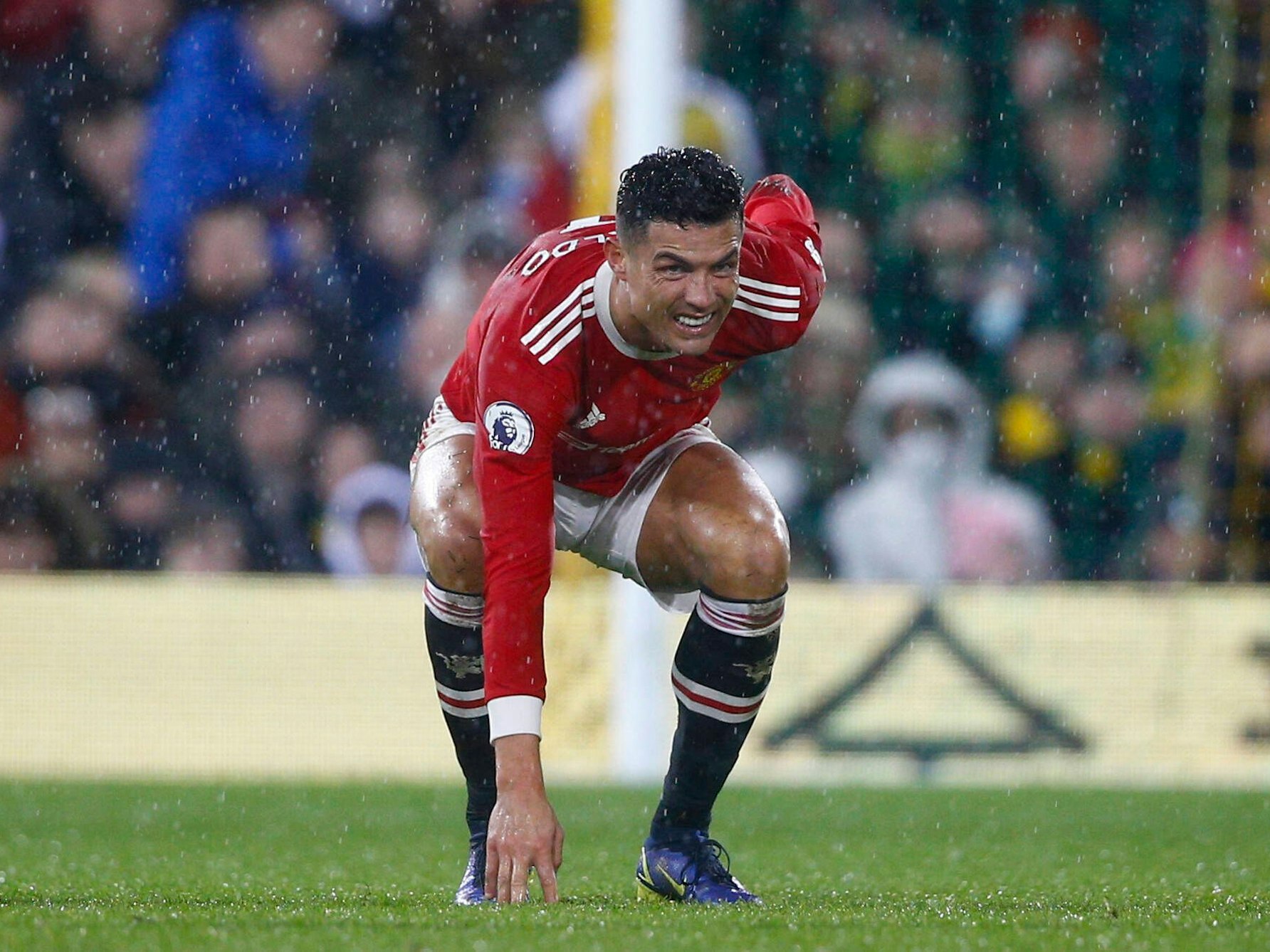 Cristiano Ronaldo hat ein schmerzverzerrtes Gesicht, geht in die Hocke und hält sich den Rücken.