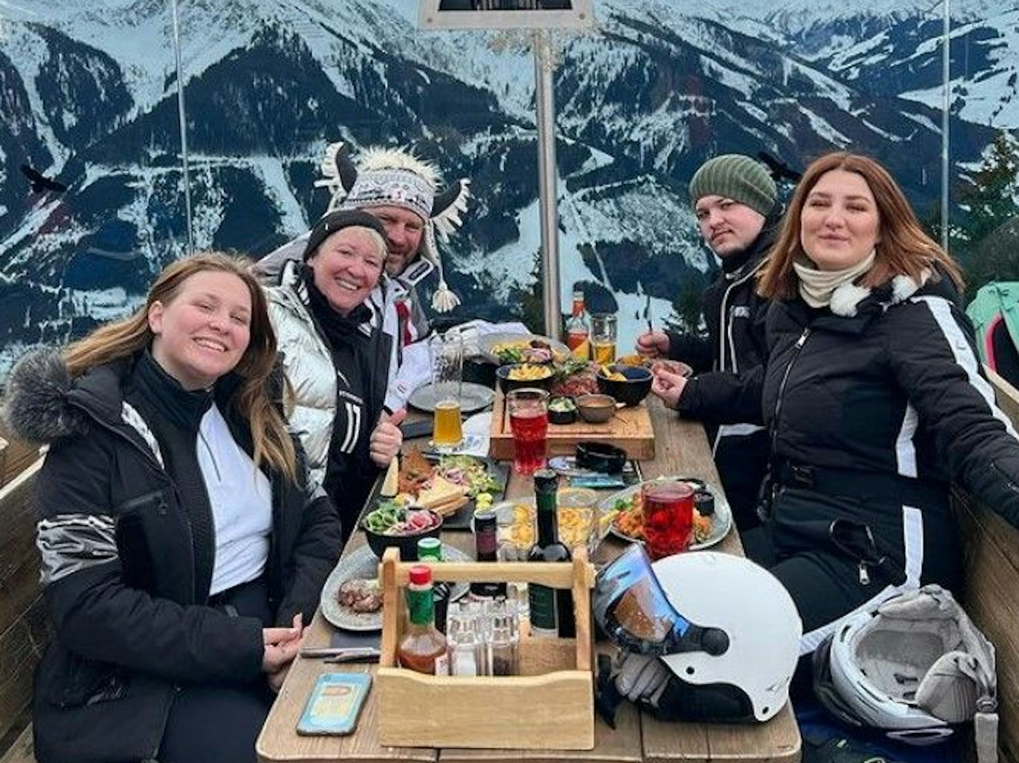 Steffen Baumgart entspannt mit seiner Familie während einer Brotzeit vor einer Skihütte.