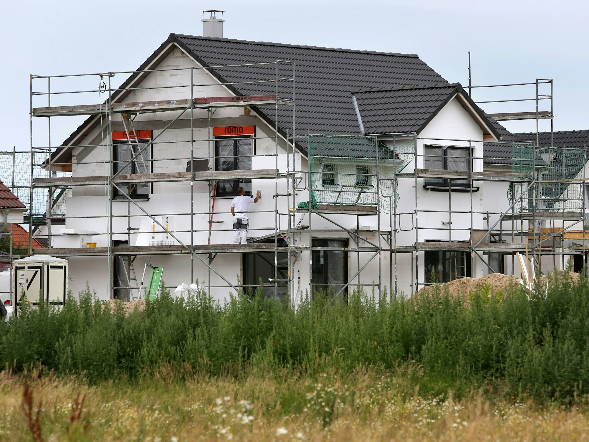 Bauarbeiter arbeiten an der Fertigstellung von Einfamilienhäusern.