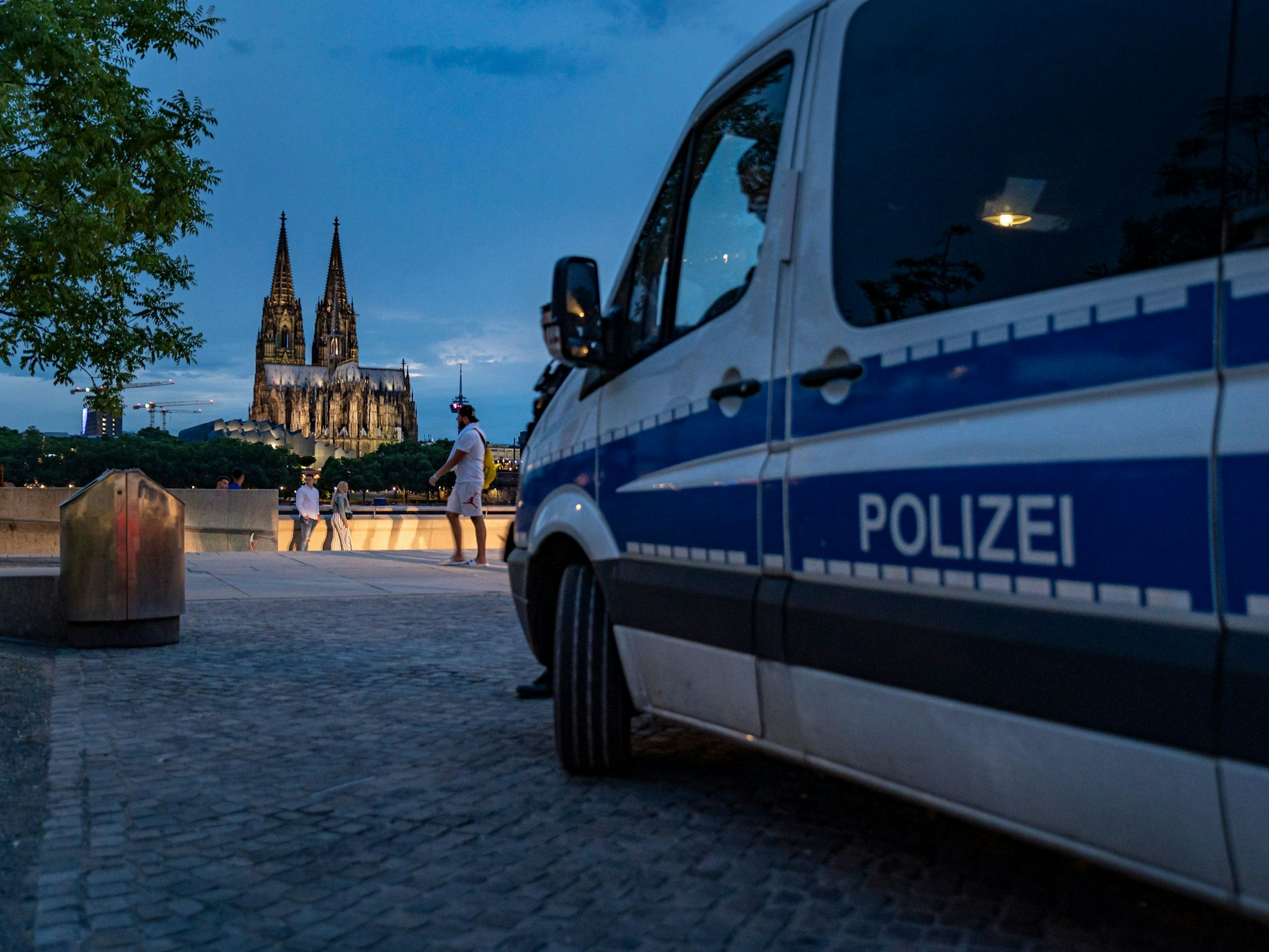 Ein Mannschaftswagen der Kölner Polizei steht während der andauernden Corona-Krise am Rheinboulevard im Kölner Stadtteil Deutz.