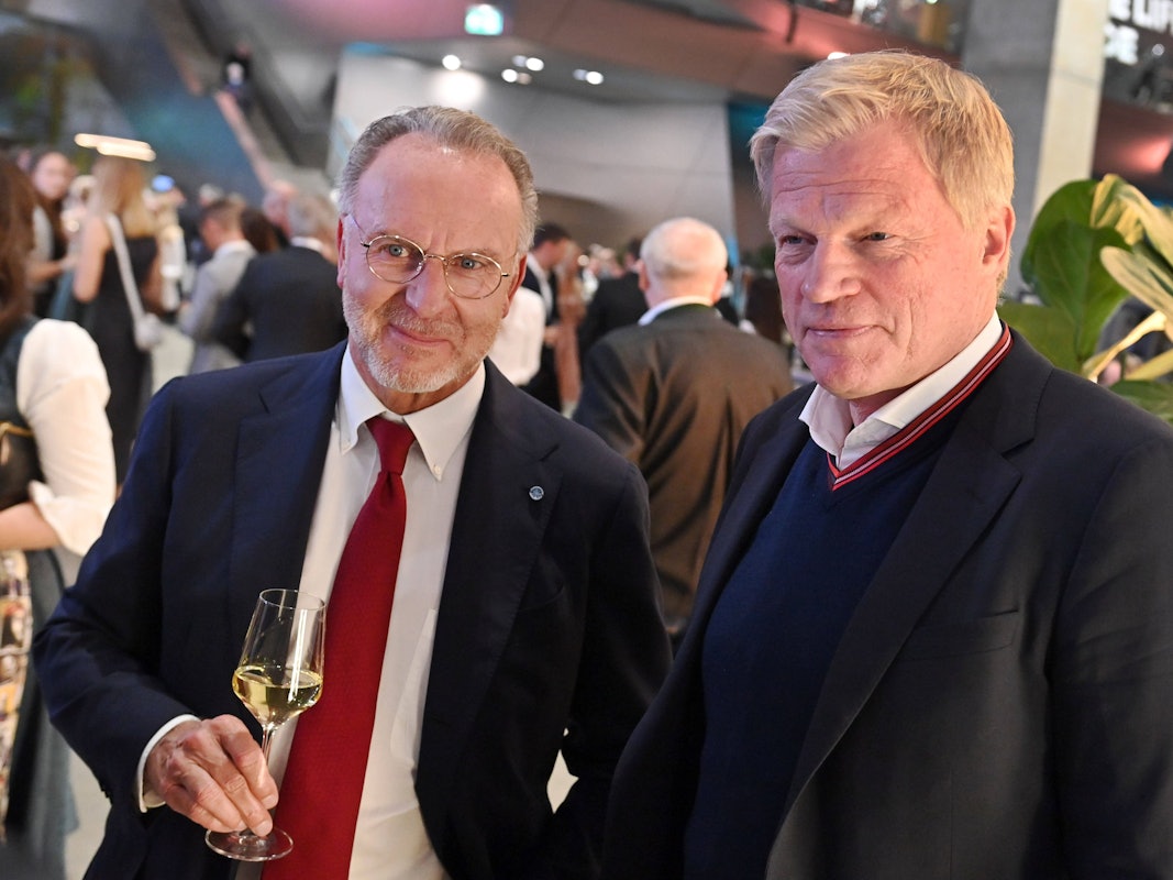 Karl-Heinz Rummenigge steht mit einem Glas Weißwein neben Oliver Kahn.