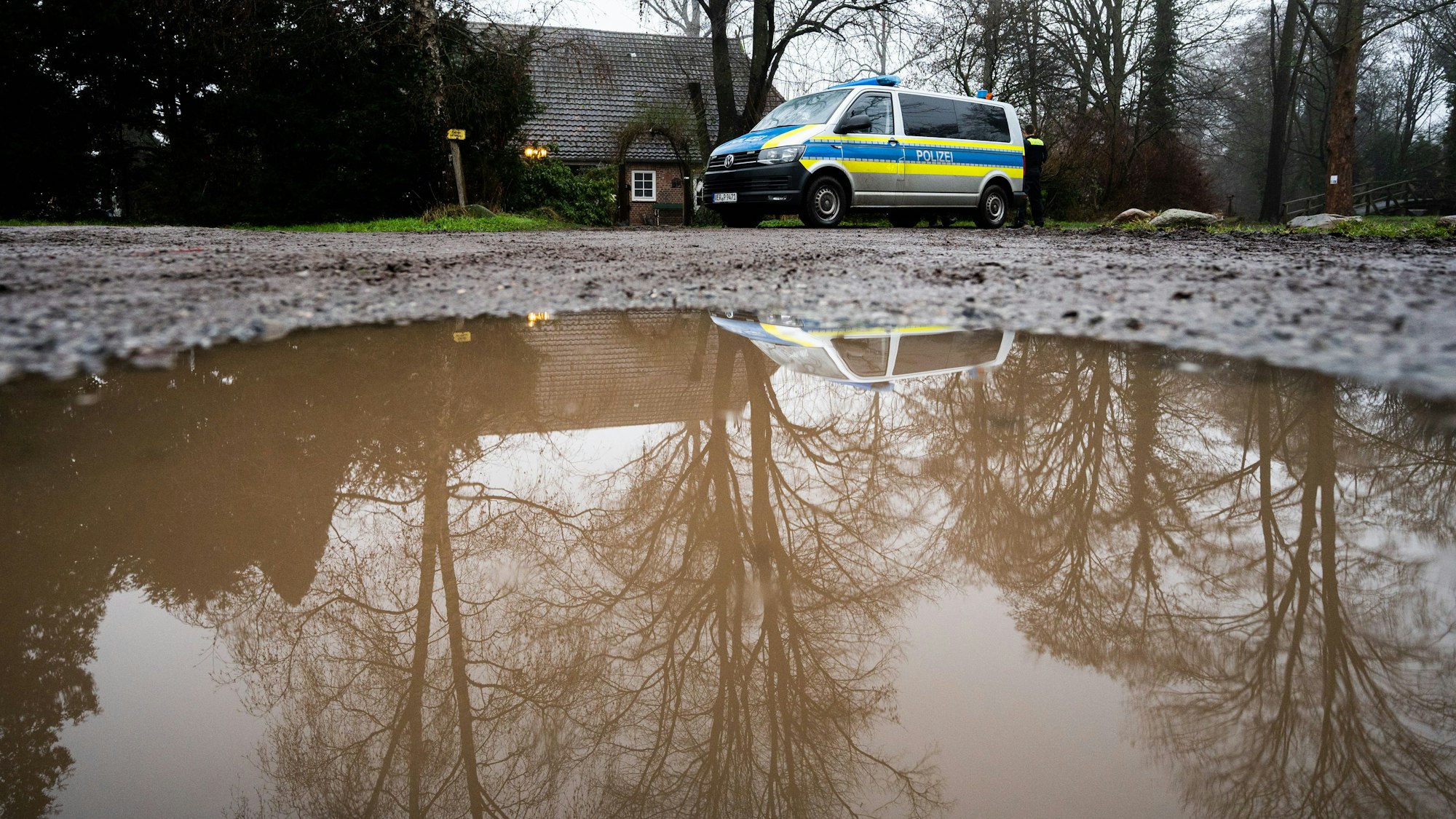 Polizisten stehen vor einem Haus, in dem am Vorabend zwei Tote aufgefunden wurden.