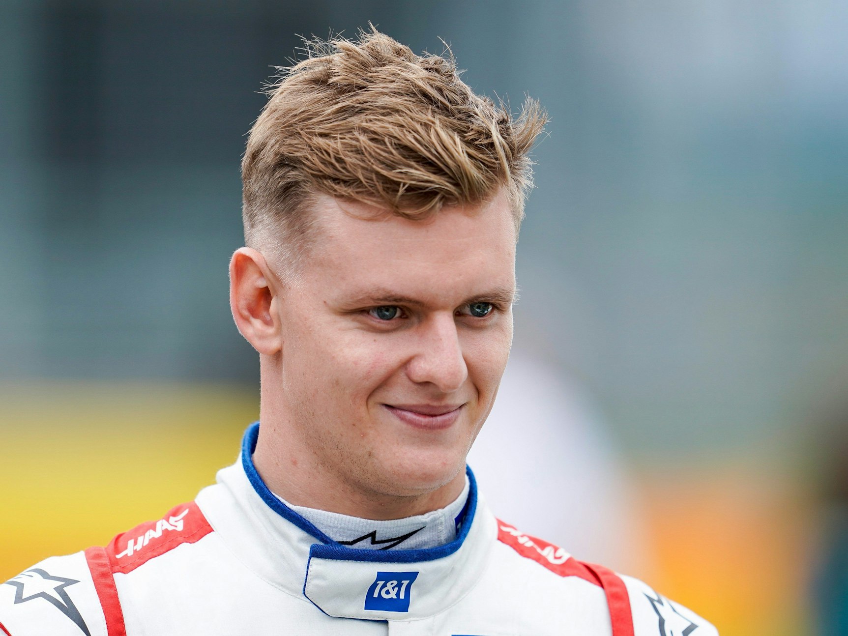Mick Schumacher im weißen Rennanzug, ohne Helm und Feuerschutzhaube.