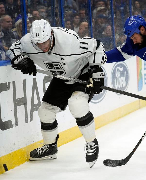 Anze Kopitar rennt der Bande entlang, um an den Puck zu kommen. Zach Bogosian ist ihm auf den Fersen.