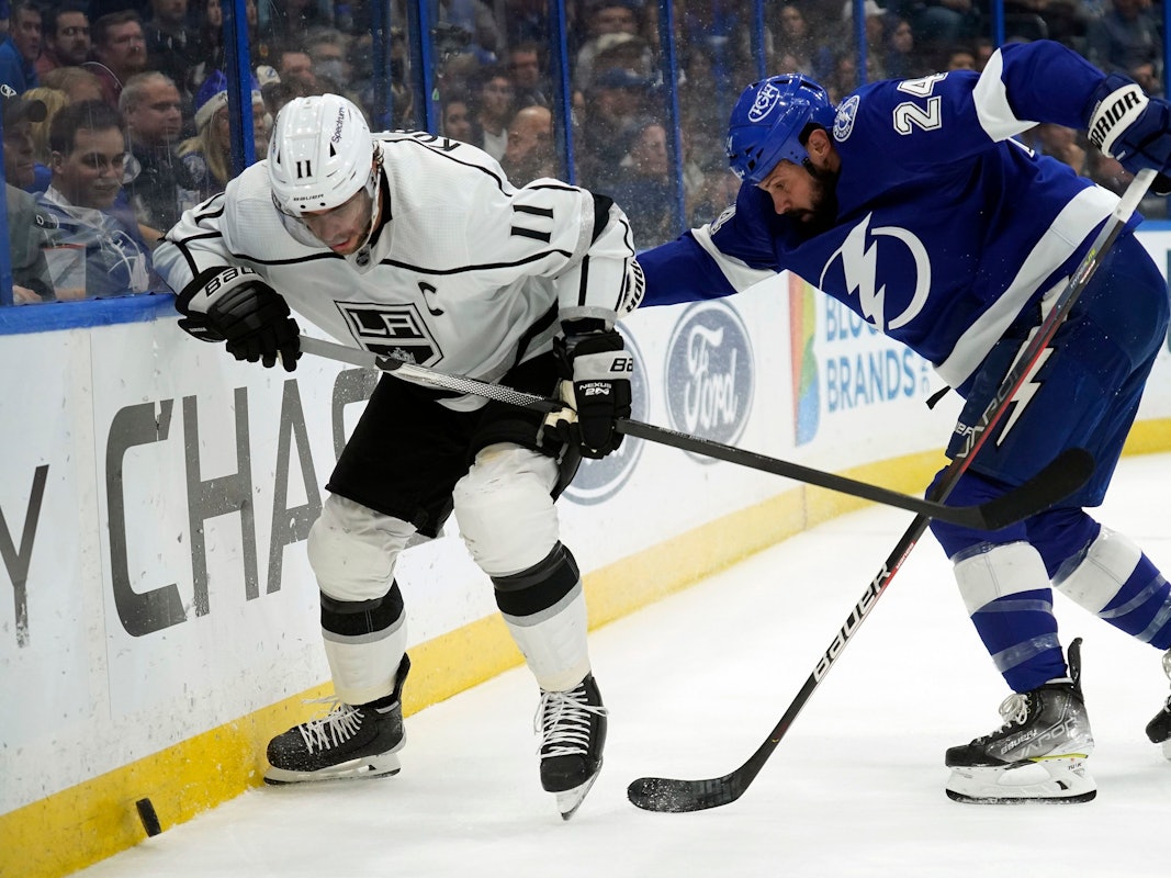 Anze Kopitar rennt der Bande entlang, um an den Puck zu kommen. Zach Bogosian ist ihm auf den Fersen.