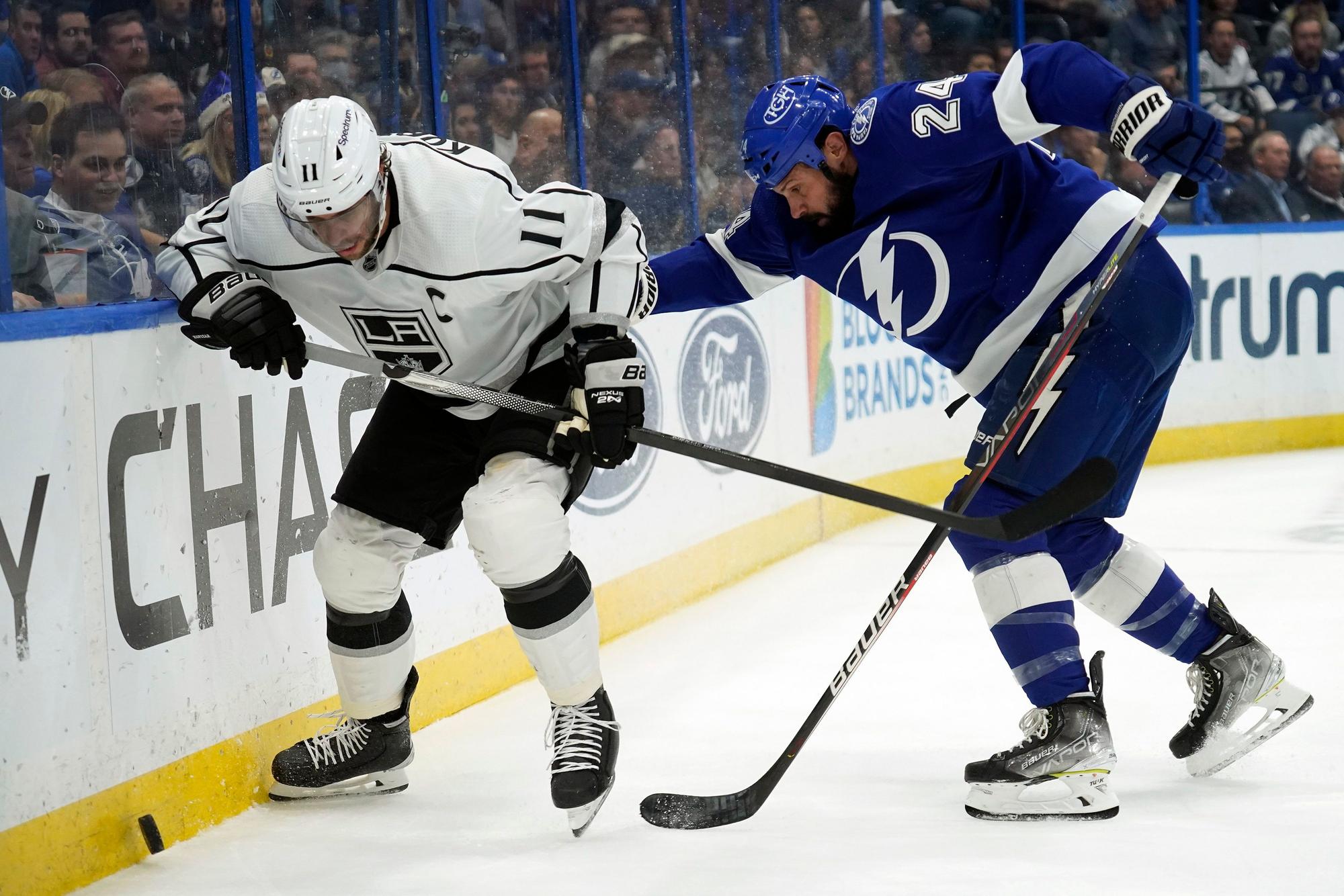 Anze Kopitar rennt der Bande entlang, um an den Puck zu kommen. Zach Bogosian ist ihm auf den Fersen.