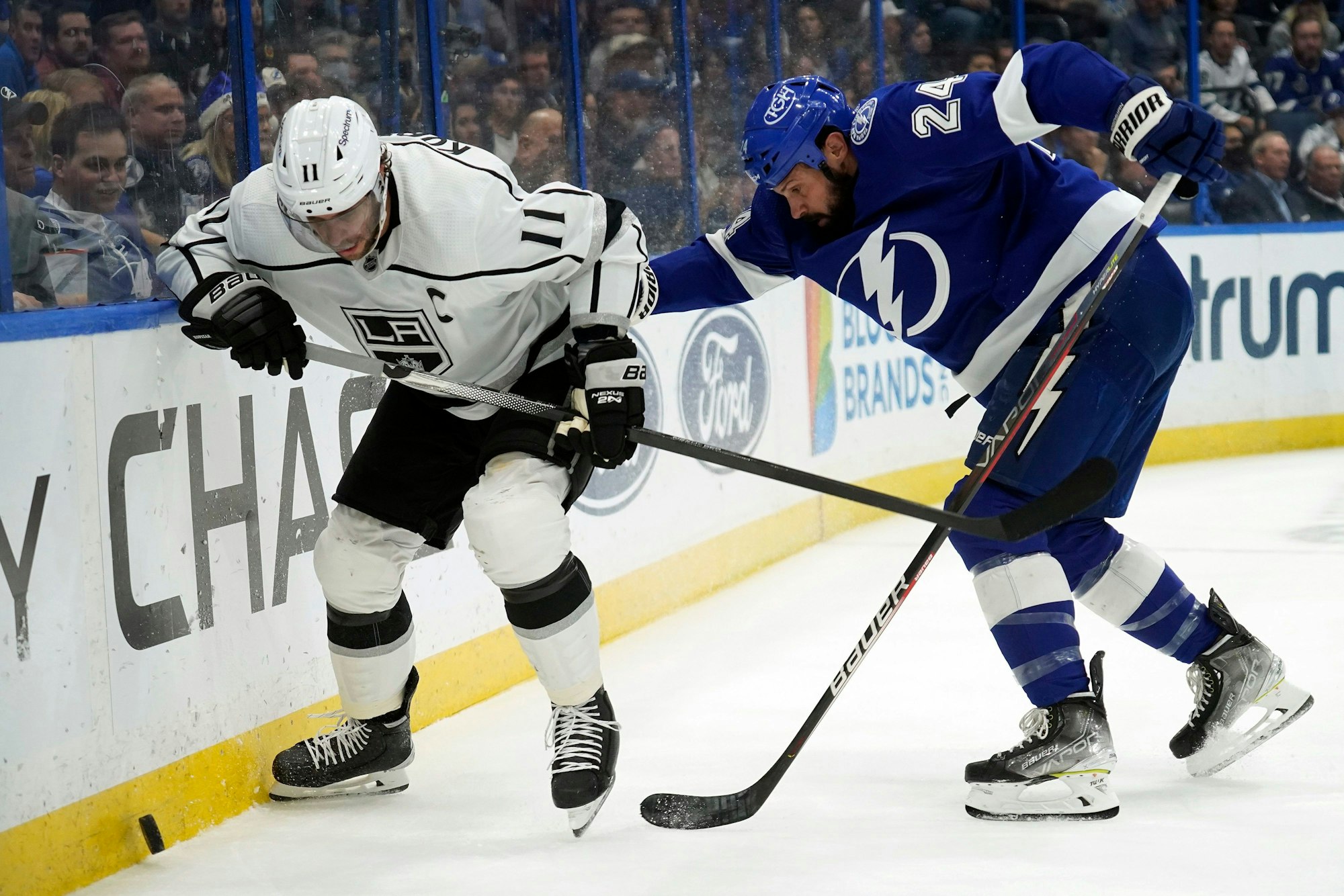 Anze Kopitar rennt der Bande entlang, um an den Puck zu kommen. Zach Bogosian ist ihm auf den Fersen.