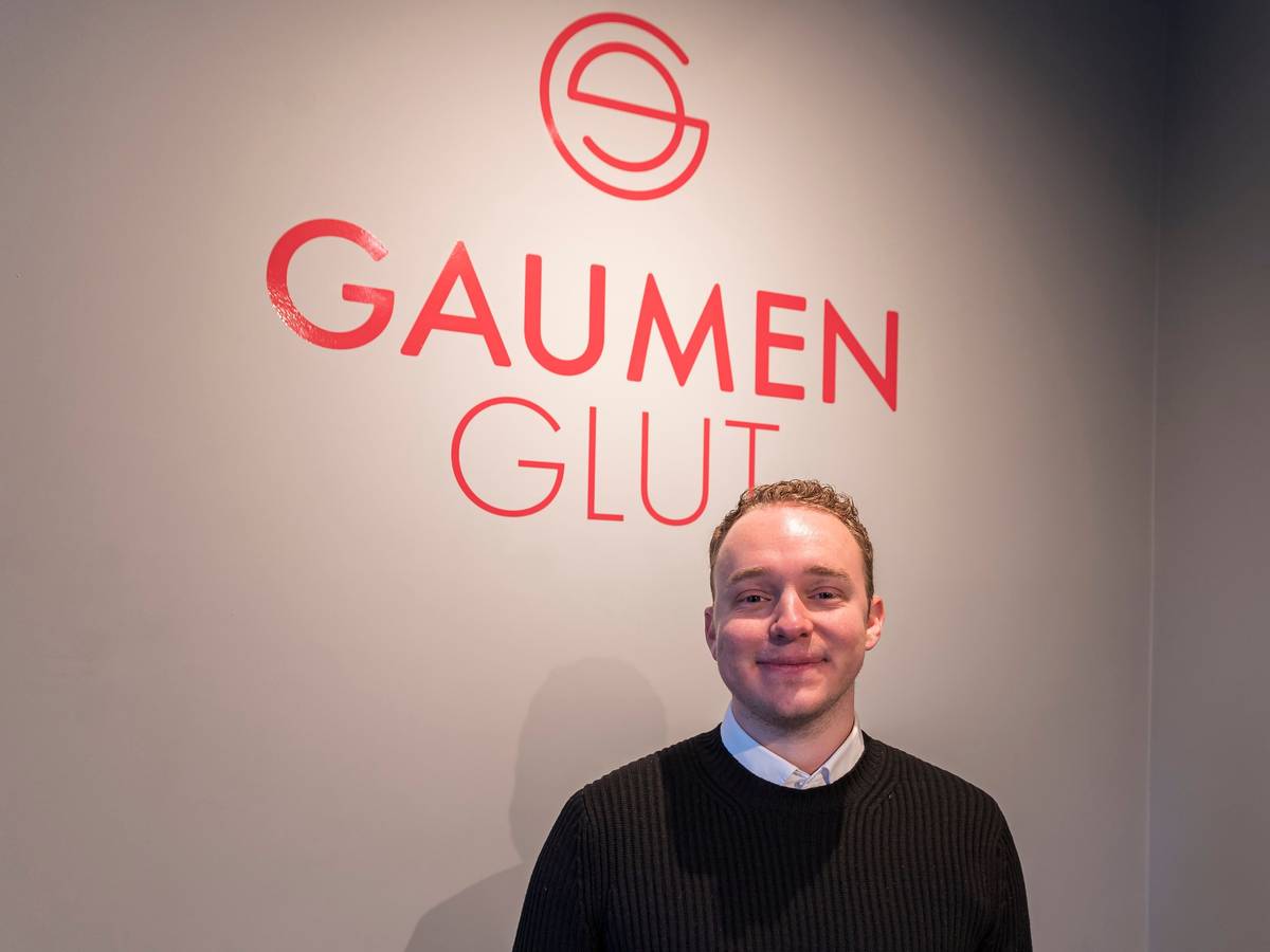 Besitzer Leon Schlichte vor dem Logo seines Restaurants.