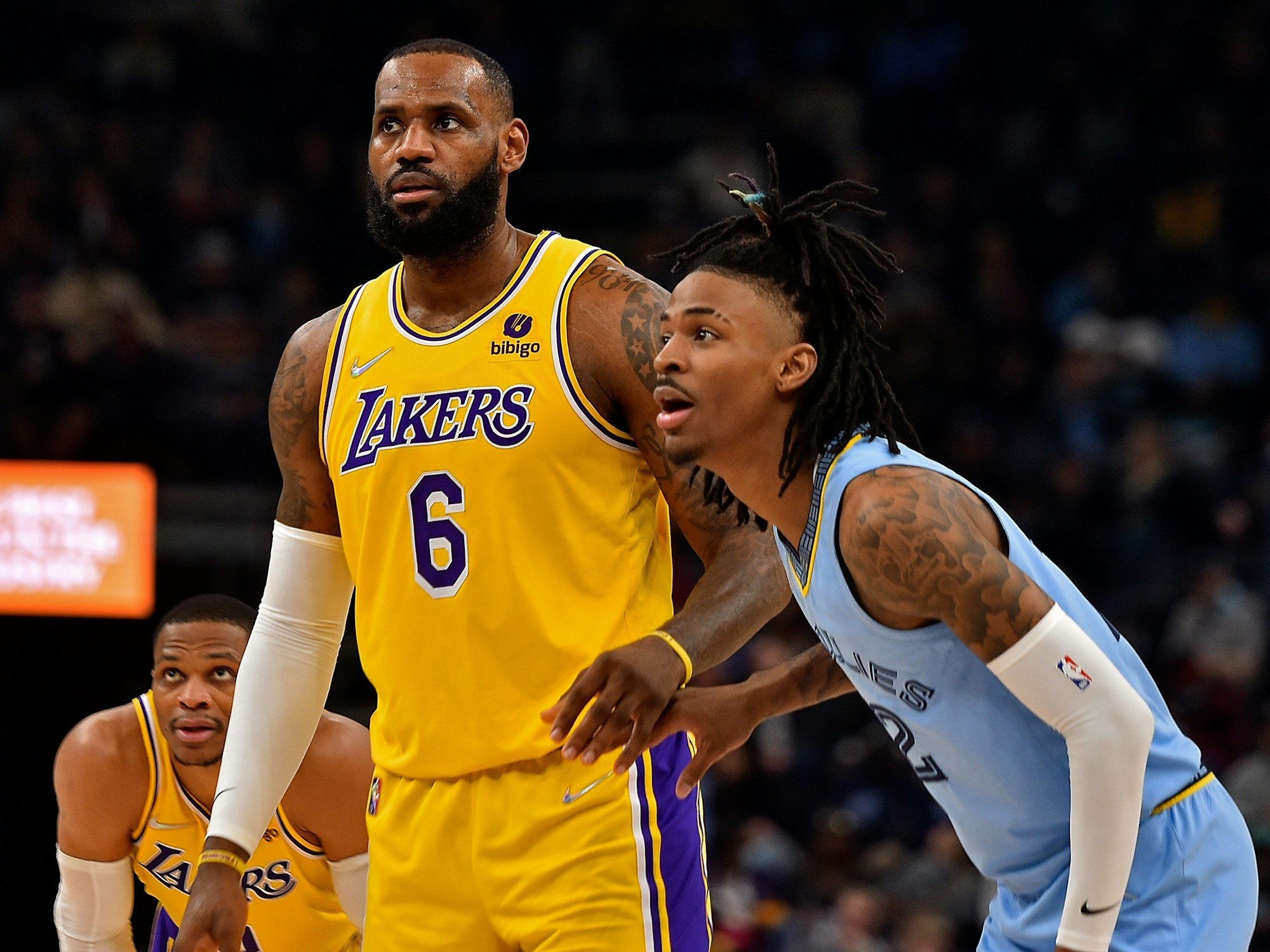 Grizzlies-Guard Ja Morant (r), LeBron James (m) und Russel Westbrook (l) schauen konzentriert auf den Ball.