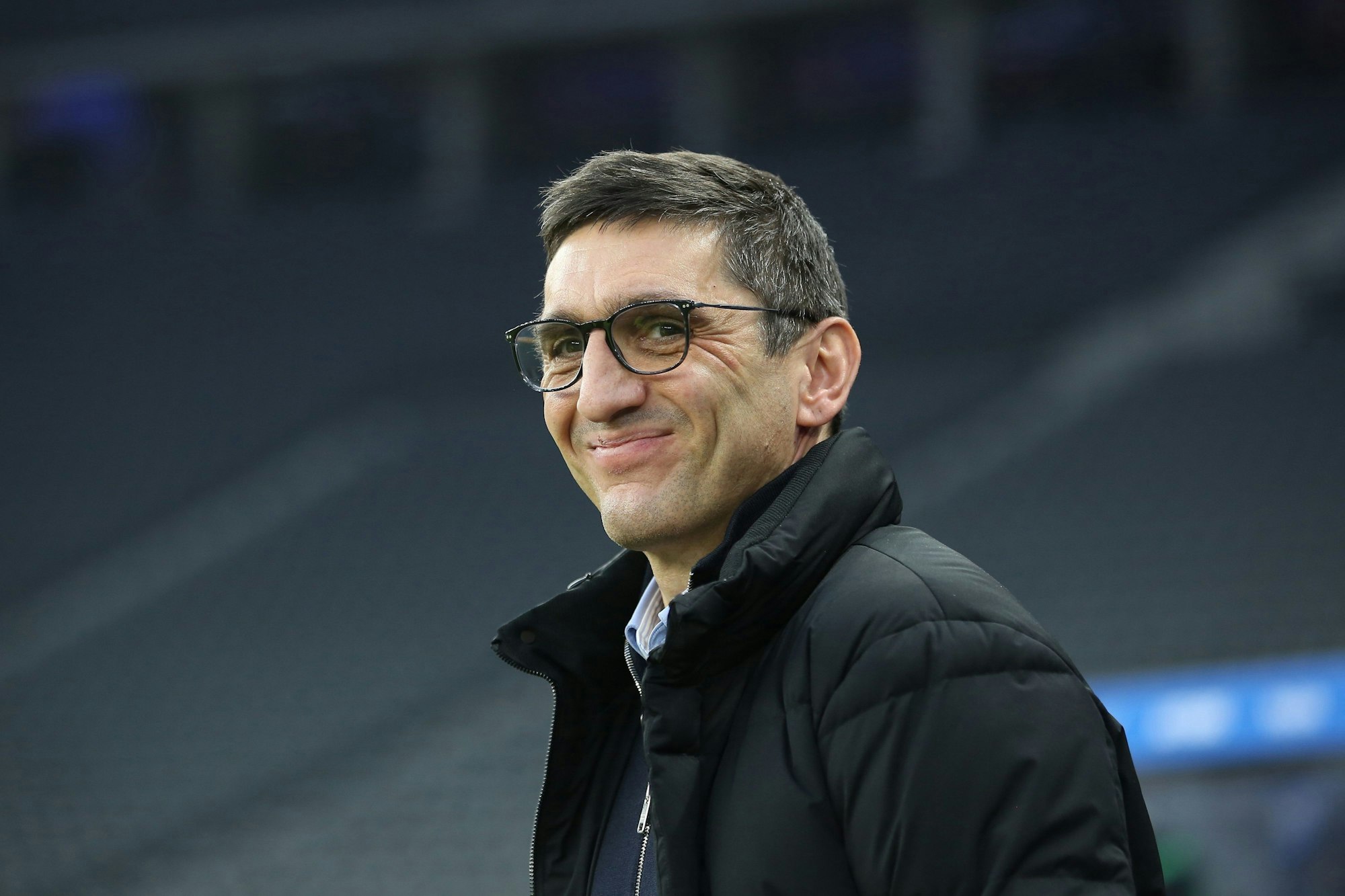 Hertha-Trainer Tayfun Korkut lächelt vor der Bundesliga-Partie gegen Arminia Bielefeld.