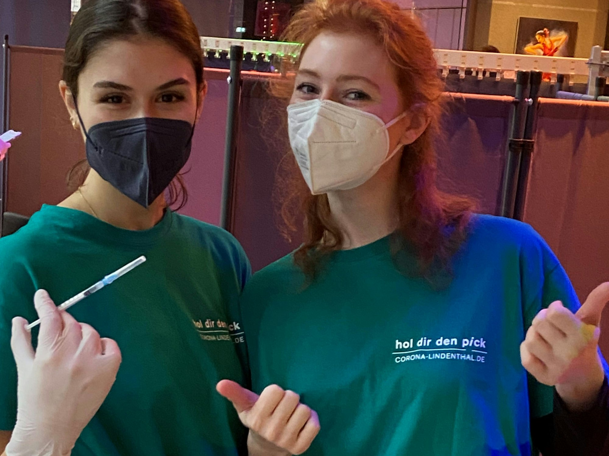 Zwei Frauen tragen Shirts mit der Aufschrift „hol dir den pick“.