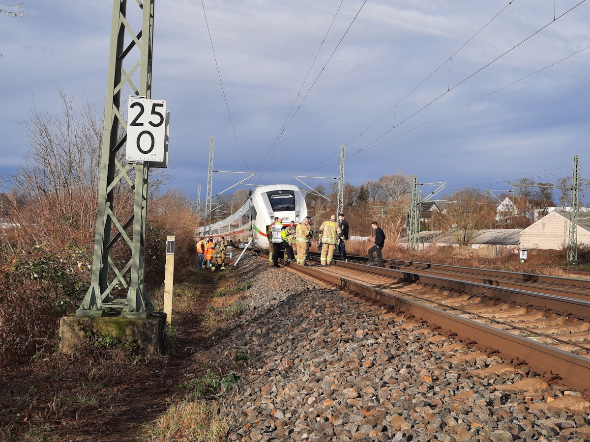Ein ICE steht auf den Gleisen, davor und daneben Experten der Deutschen Bahn, die sich den Schaden an der Oberleitung angucken.
