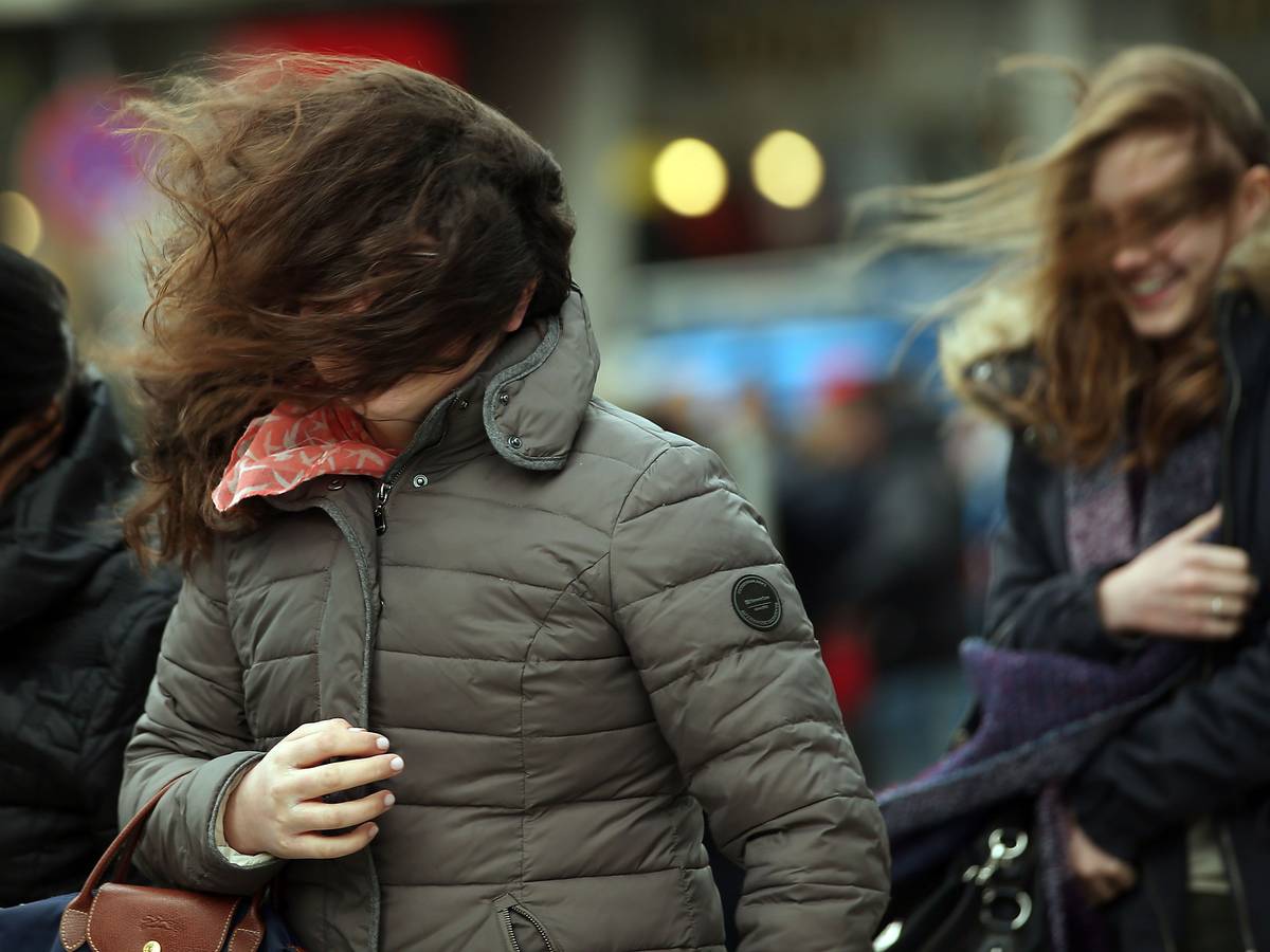 Mit durcheinandergewirbelten Haaren gehen am 31.03.2015 in Köln (Nordrhein-Westfalen) junge Frauen über die Domplatte.
