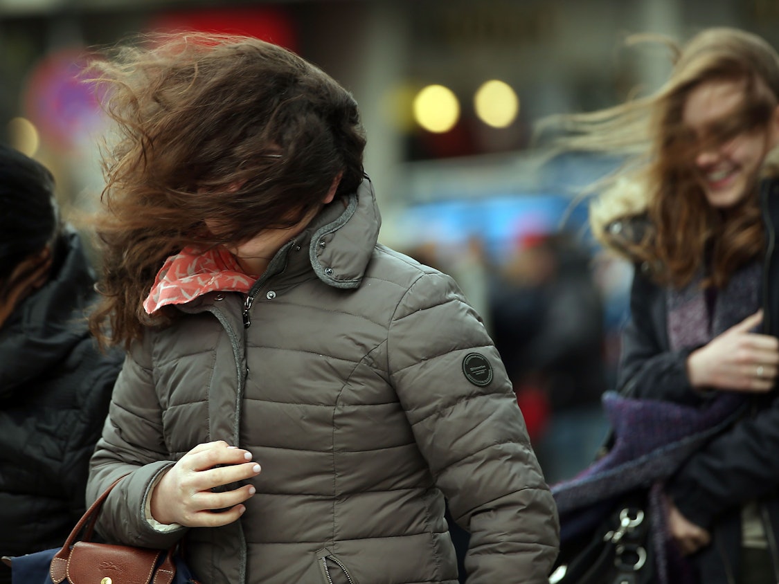 Mit durcheinandergewirbelten Haaren gehen am 31.03.2015 in Köln (Nordrhein-Westfalen) junge Frauen über die Domplatte.