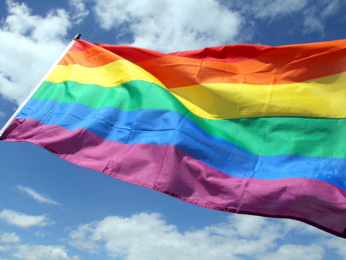 Die wehende Regenbogenflagge der LGBTQI+-Communitys wird auch Pride-Flagge genannt.