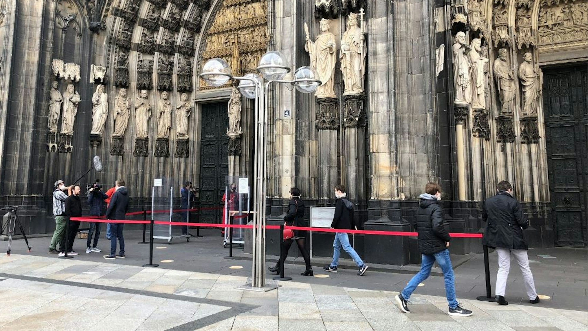 Besucher warten am Eingang des Kölner Doms.